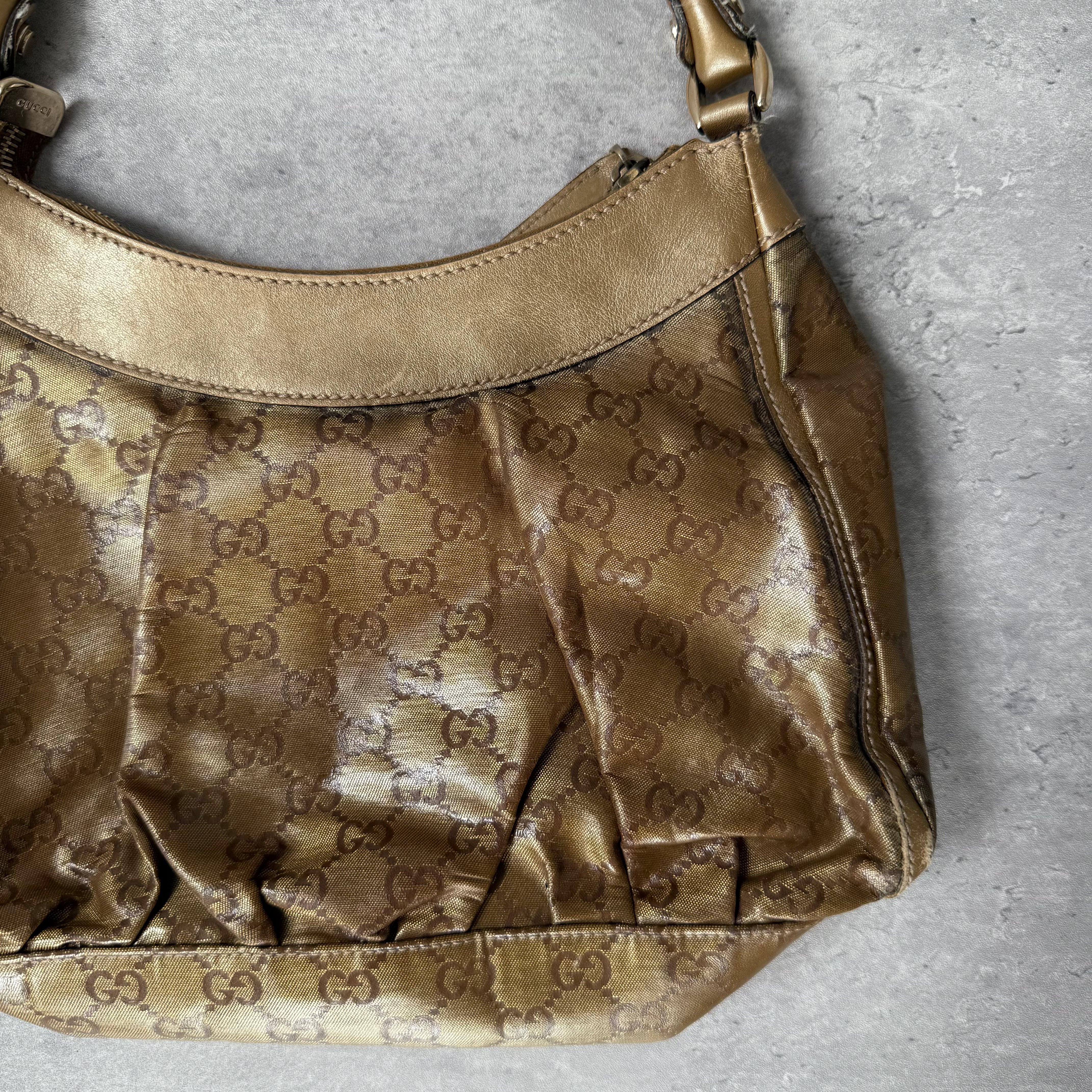 Gucci GG Monogram D-Ring Shoulder Bag in metallic gold with patent leather trim, pleated body, and gold-tone hardware.
