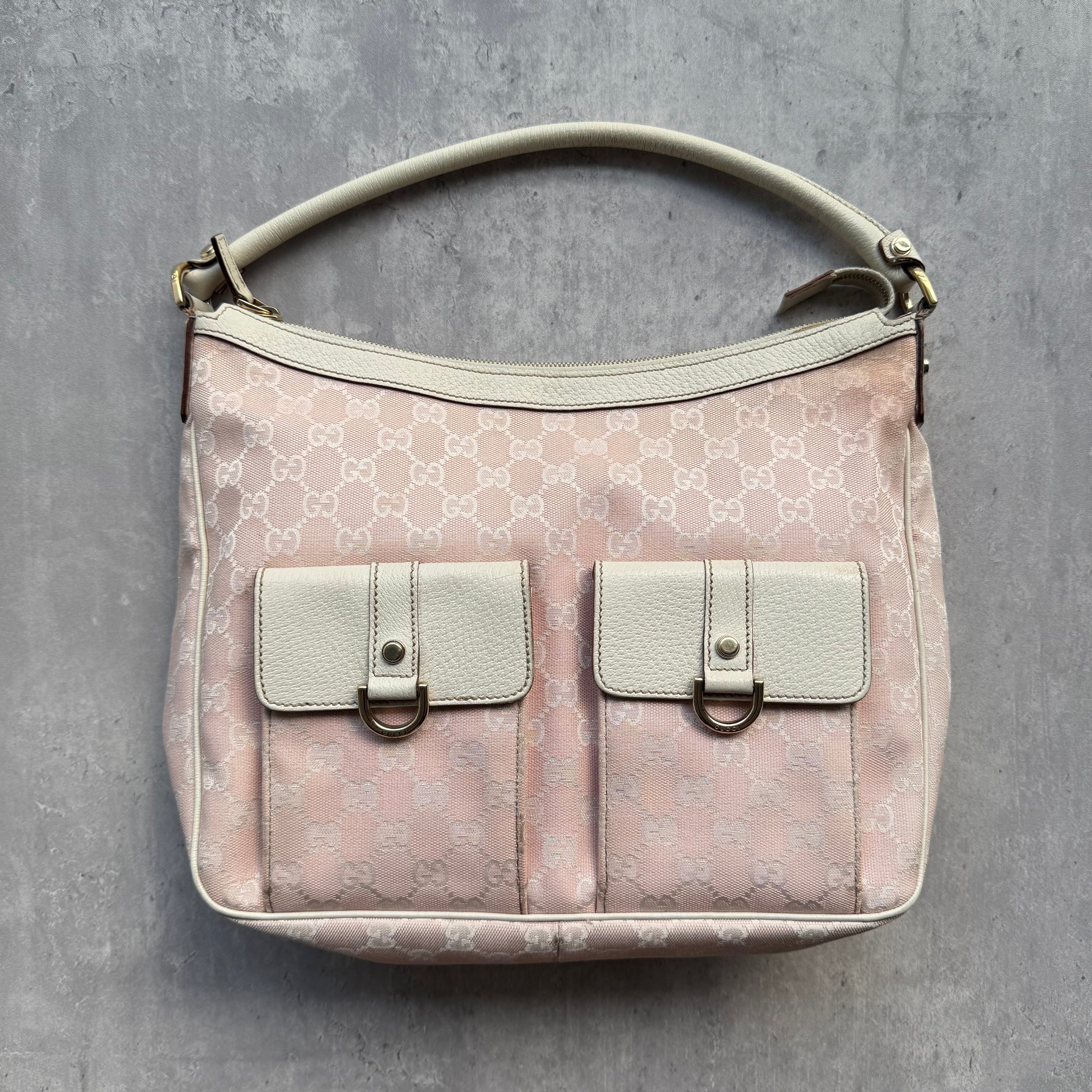 Gucci GG Monogram Hobo Shoulder Bag Pink, featuring ivory leather trim, front flap pockets, and gold-tone hardware with a blush fabric interior
