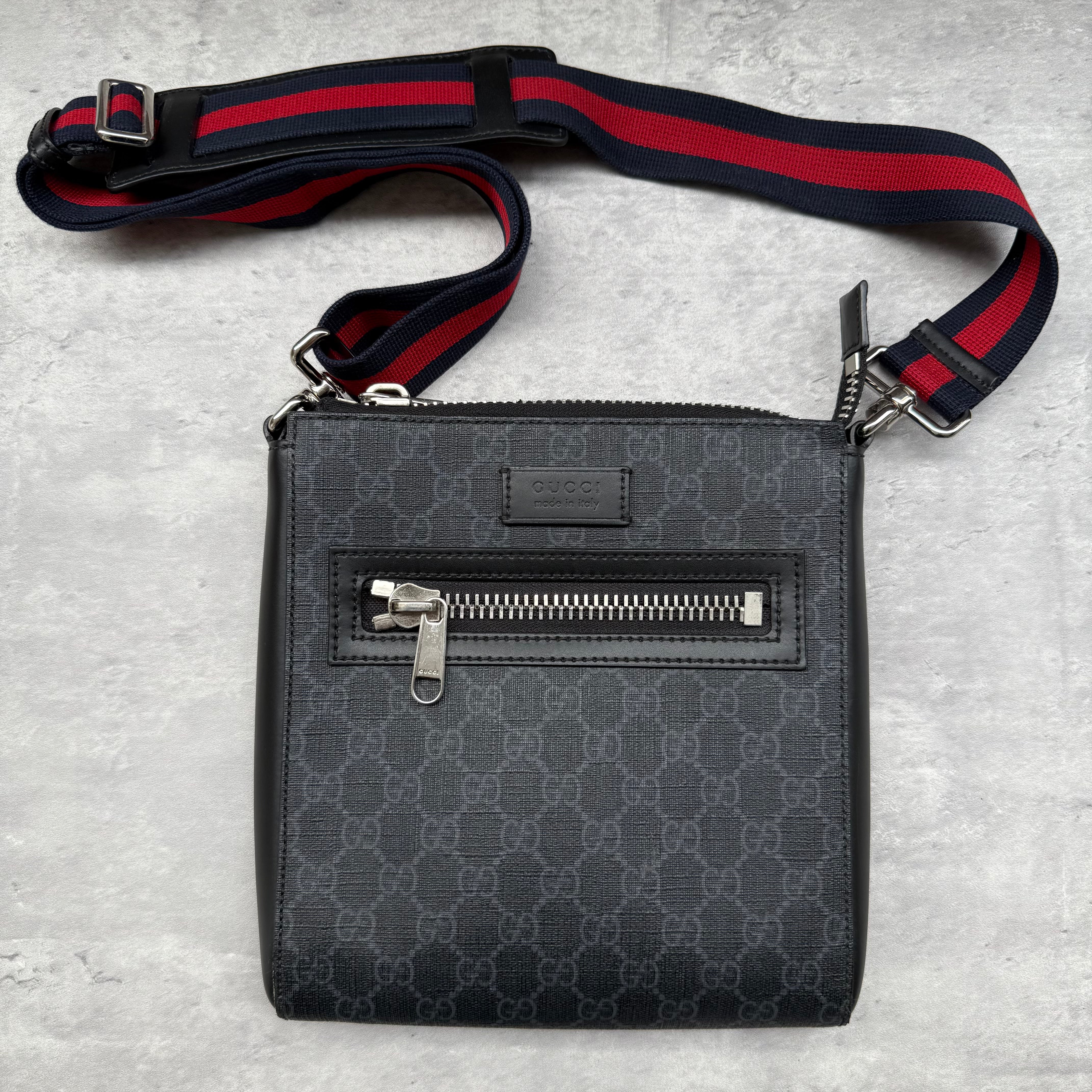 Gucci GG Monogram Messenger Bag in grey canvas with red and navy web strap, front zip pocket, silver-tone hardware, and original box.