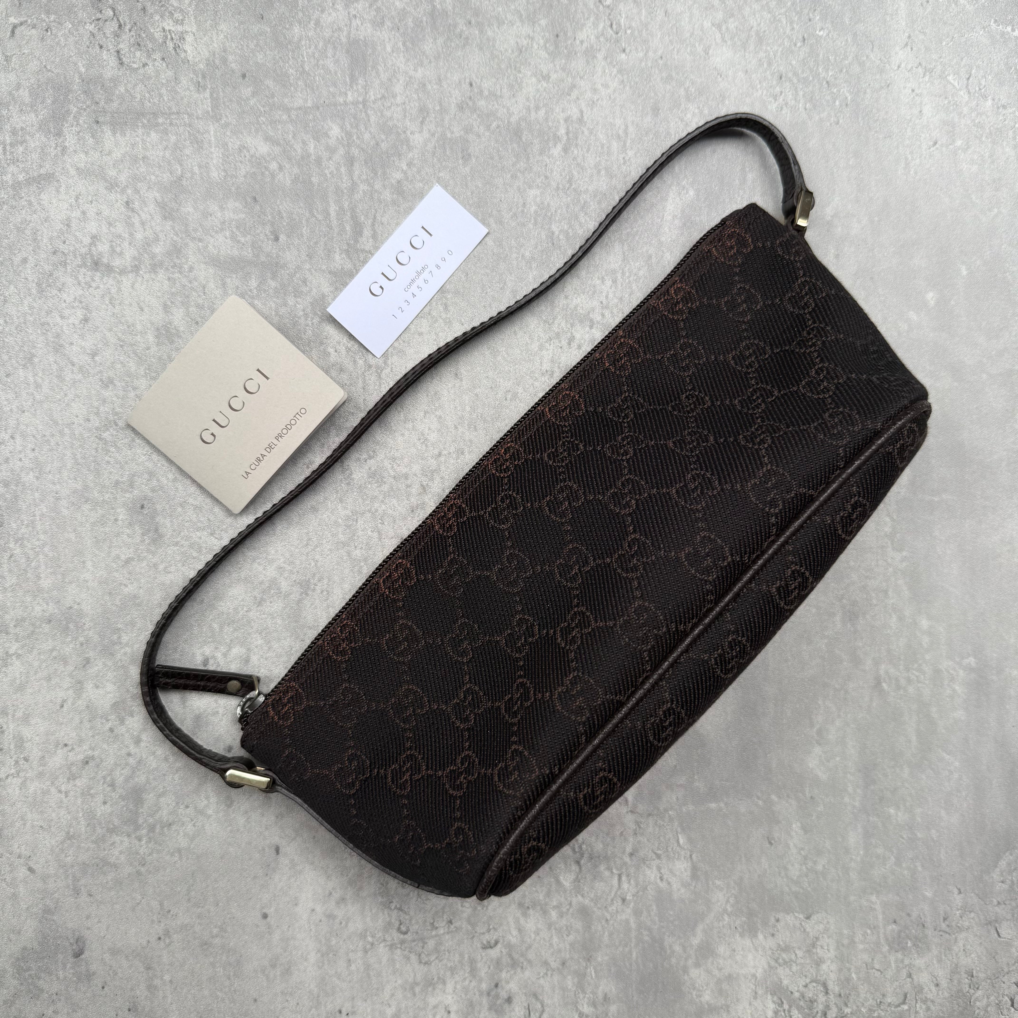 Gucci GG Monogram Pochette Boat Shoulder Bag in black canvas with tonal trim, top zip closure, and minimalist silhouette.