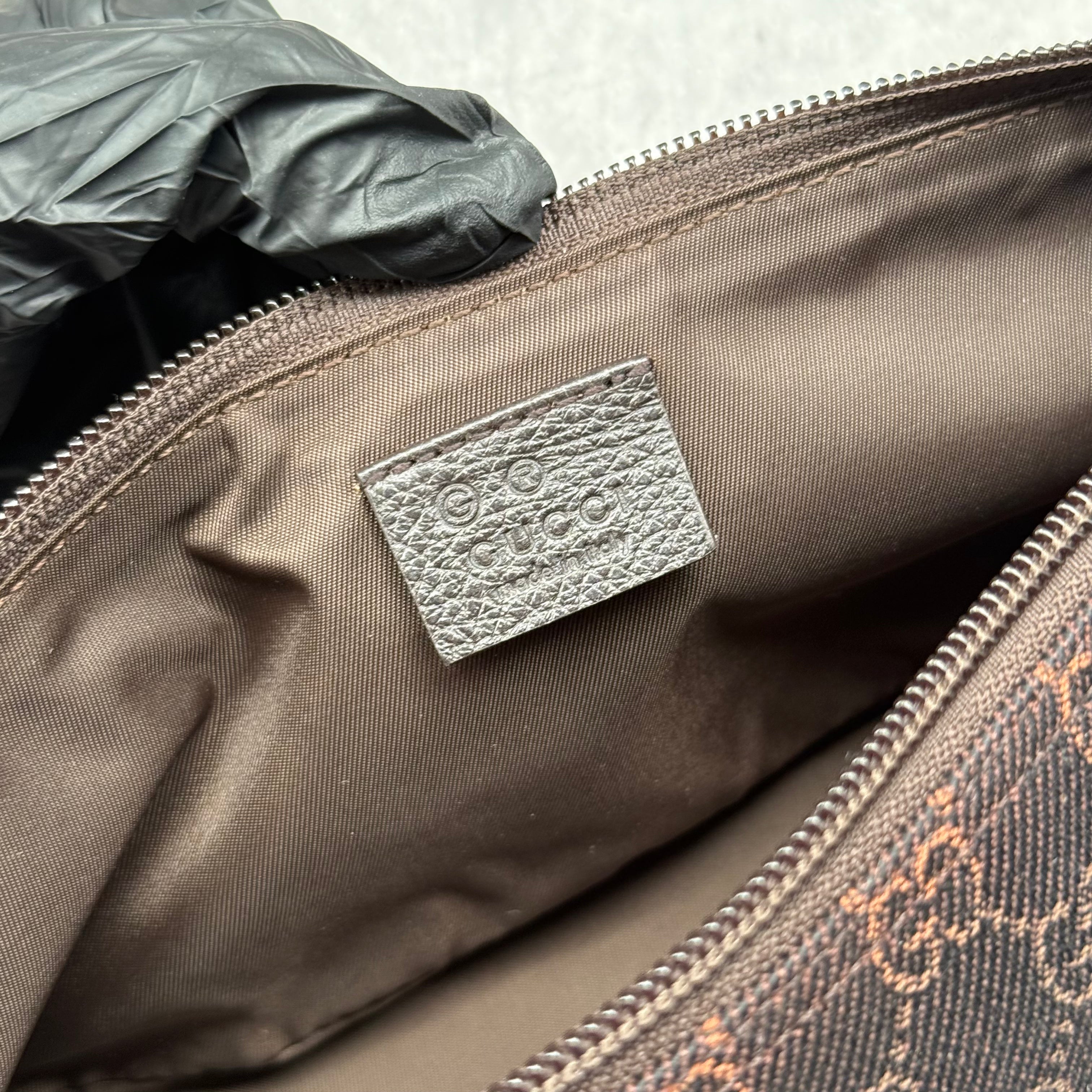 Gucci GG Monogram Pochette Boat Shoulder Bag in black canvas with tonal trim, top zip closure, and minimalist silhouette.