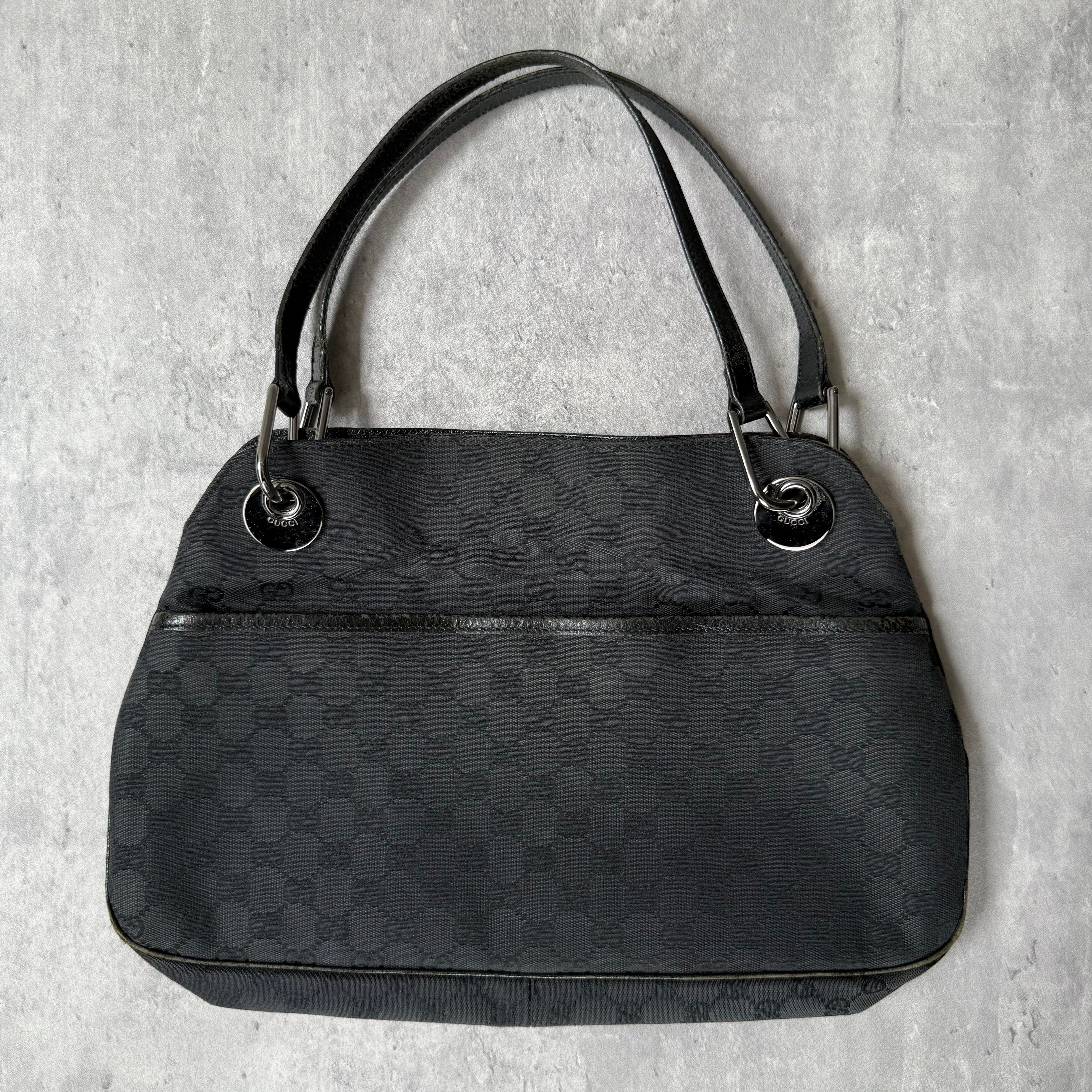 Gucci GG Monogram Shoulder Bag in black canvas with leather trim, silver-tone grommets, and spacious interior.