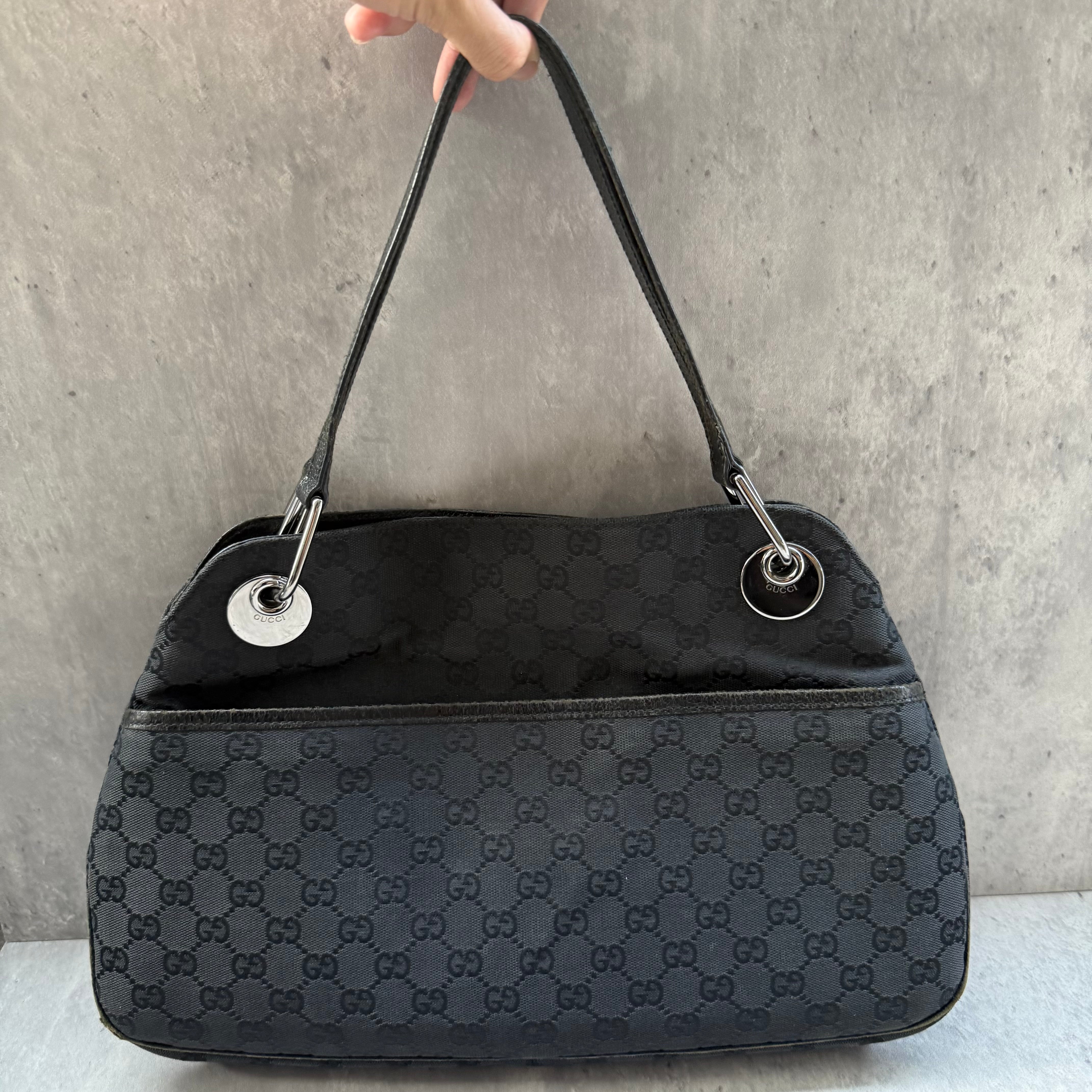 Gucci GG Monogram Shoulder Bag in black canvas with leather trim, silver-tone grommets, and spacious interior.