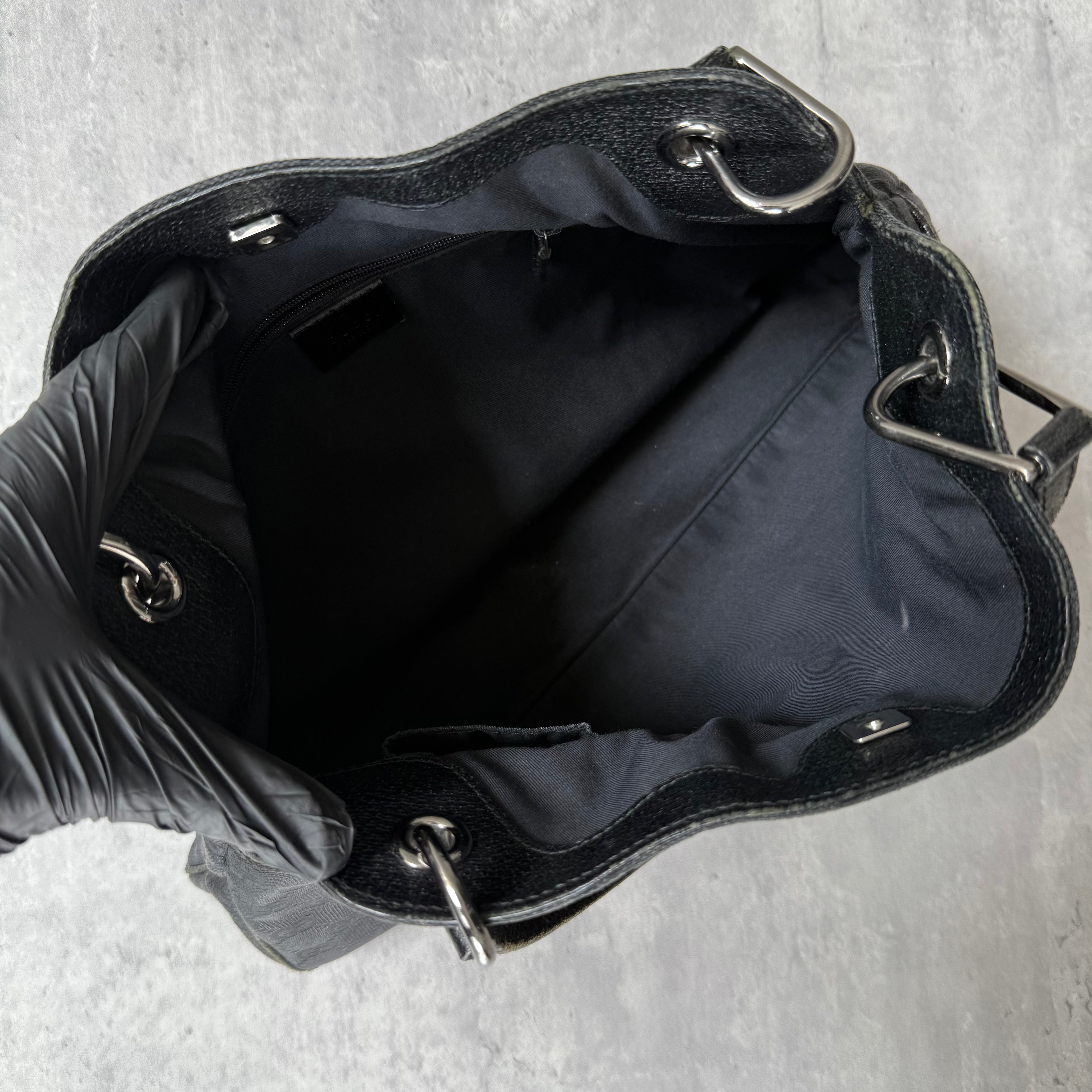 Gucci GG Monogram Shoulder Bag in black canvas with leather trim, silver-tone grommets, and spacious interior.