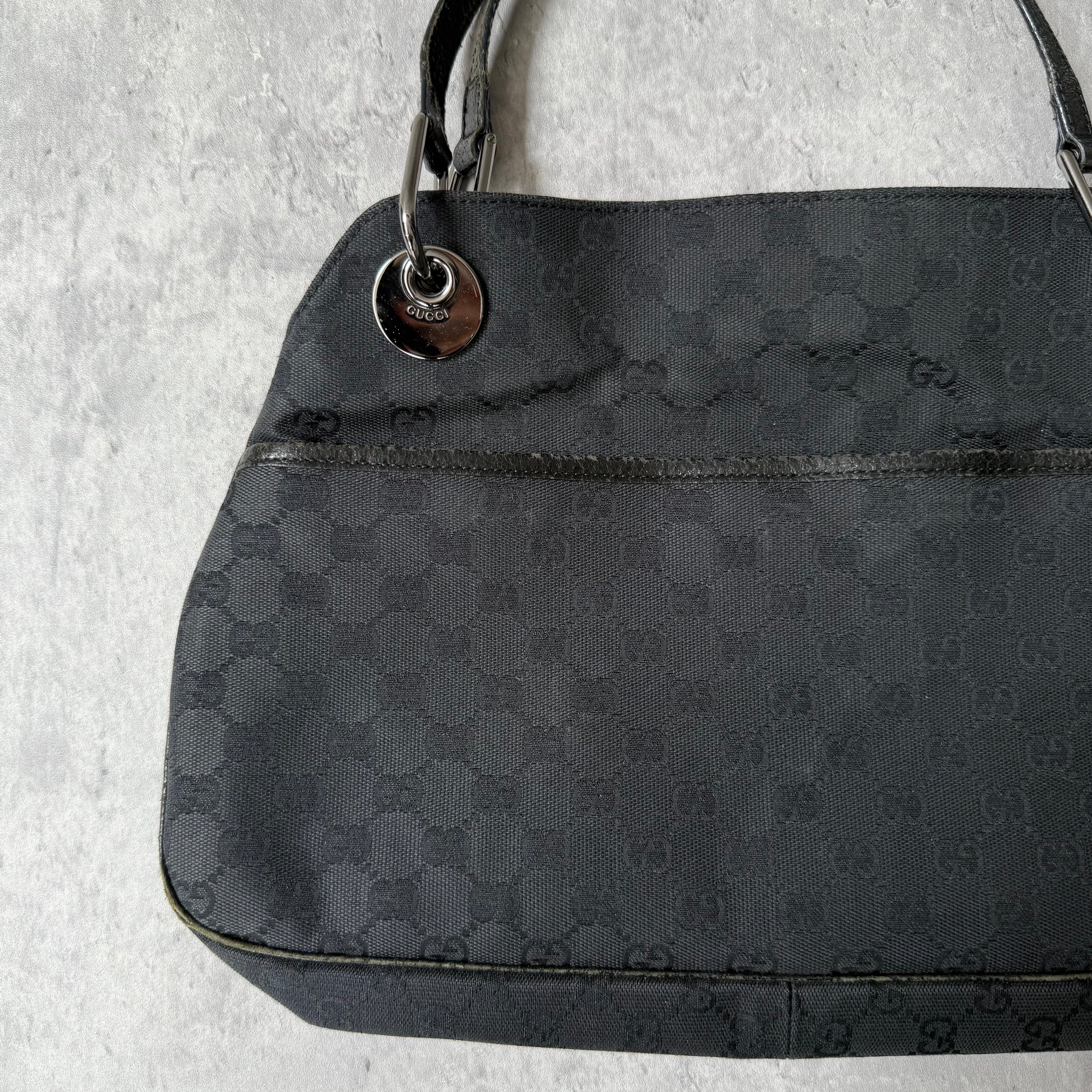 Gucci GG Monogram Shoulder Bag in black canvas with leather trim, silver-tone grommets, and spacious interior.