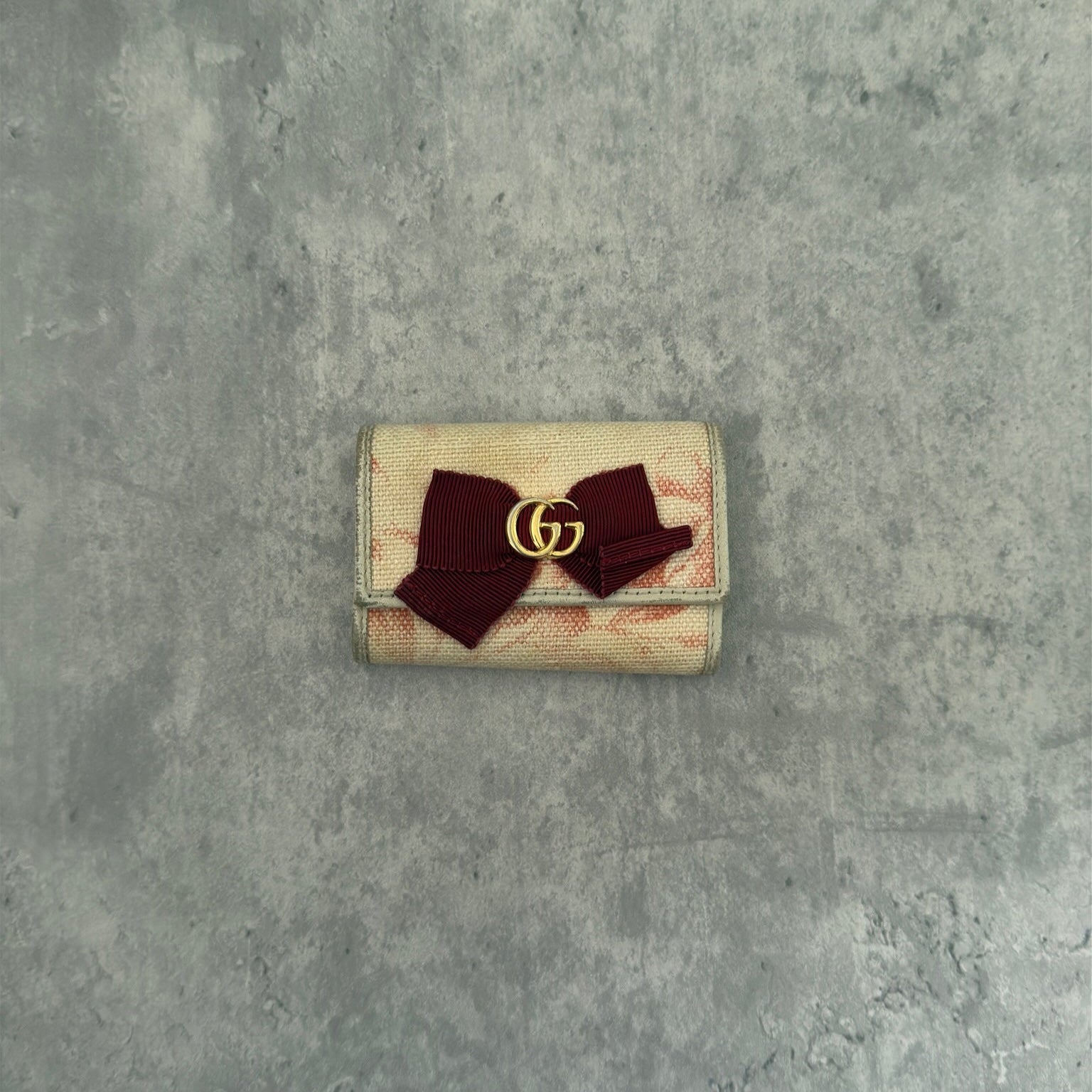 Gucci Herbarium floral pattern key case in beige with red bow, multiple key hooks, and snap closure, available exclusively at Elevated Studios.