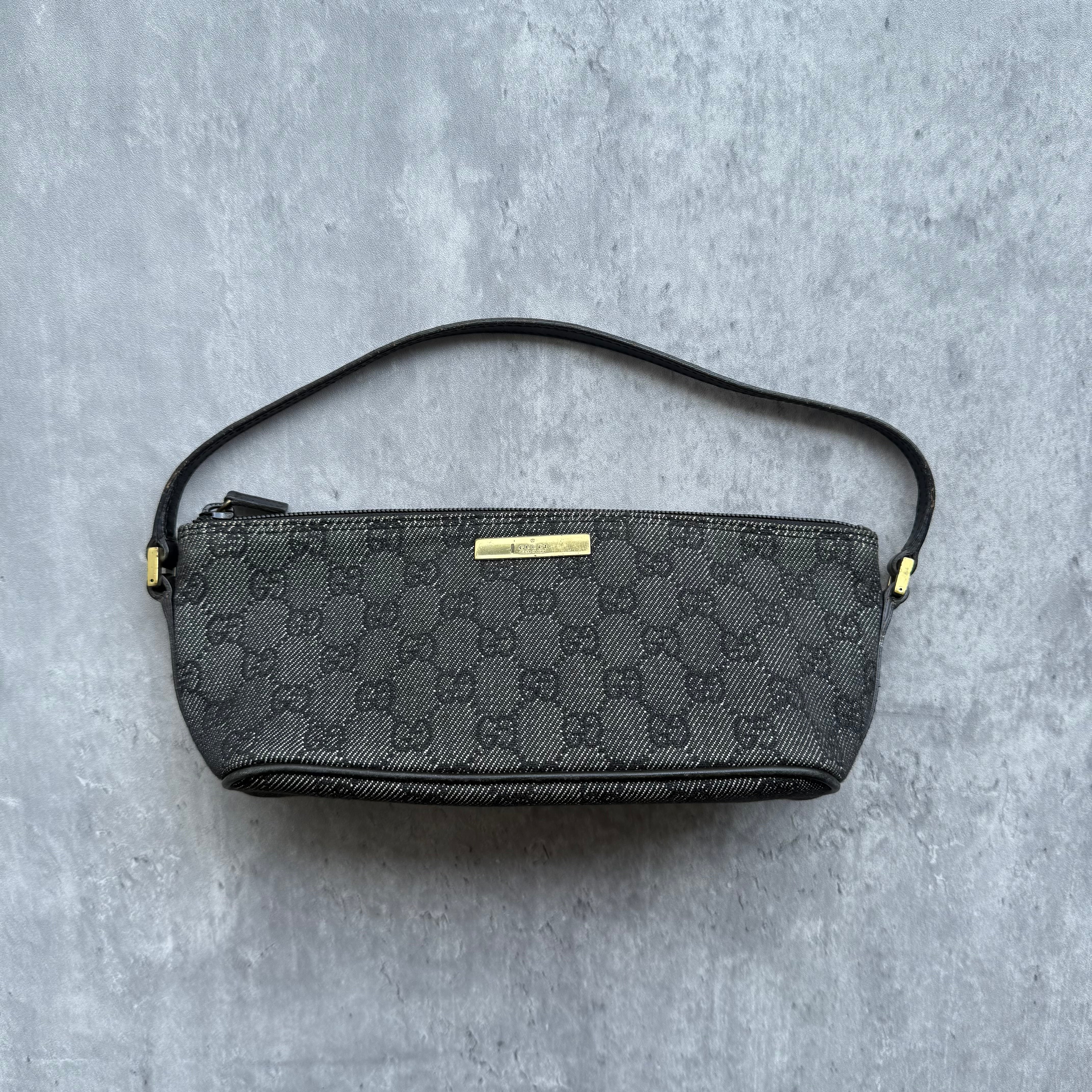 Gucci Pochette Boat Shoulder Bag in black GG monogram canvas with gold-tone logo plaque and black leather strap.