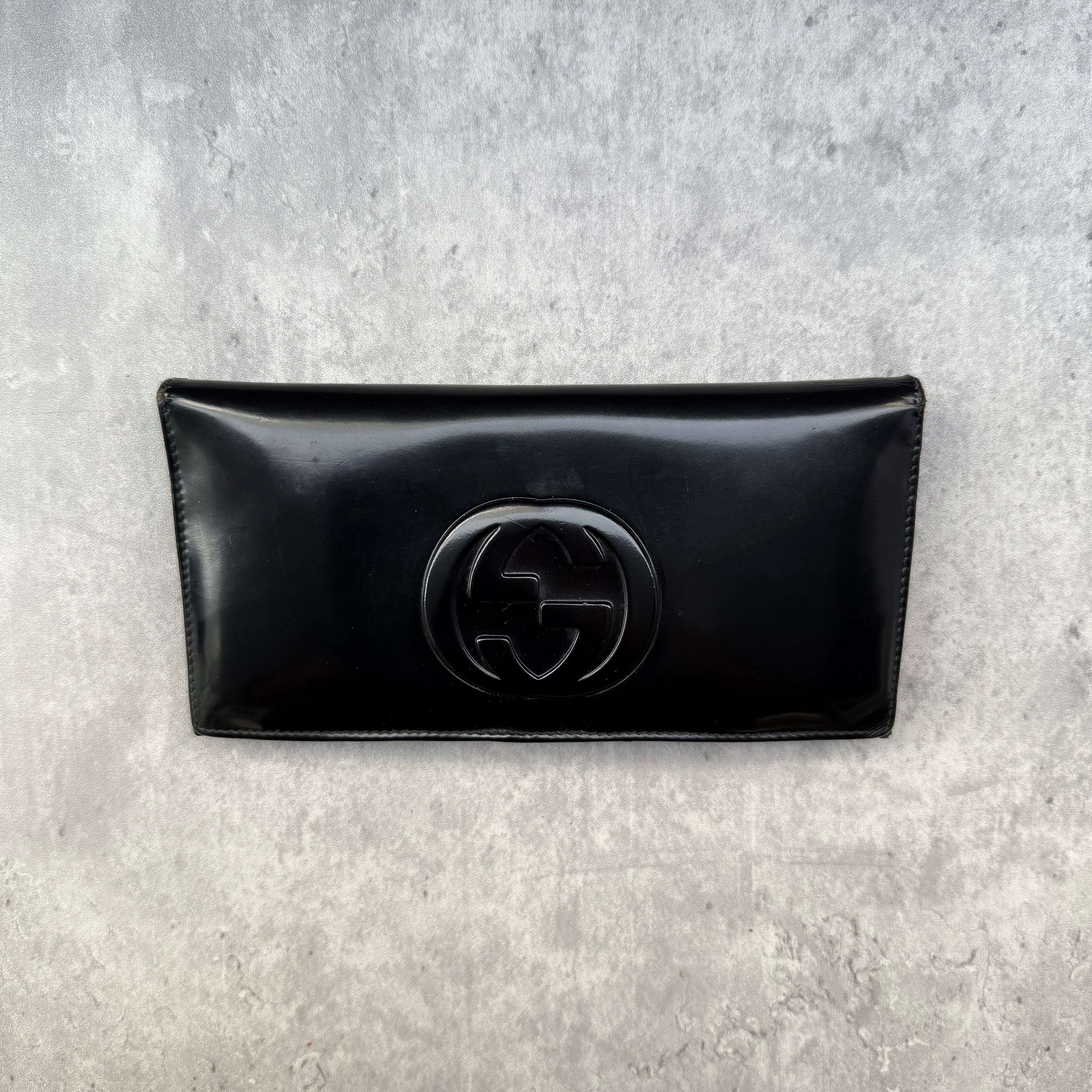 Gucci black patent leather bifold wallet with interlocking GG logo, original Gucci care card, and structured compartments