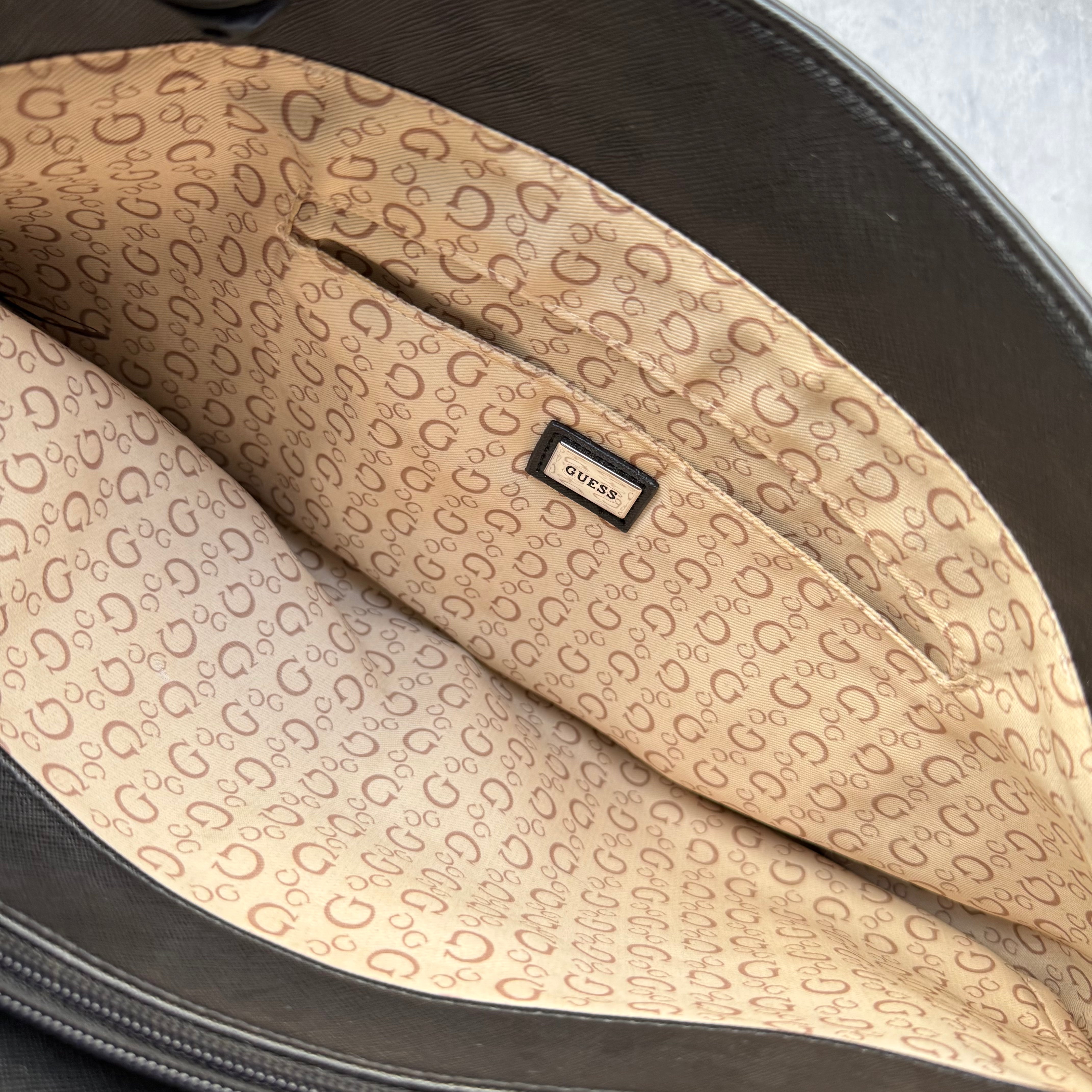 Guess Monogram Print Carryall Tote Bag in glossy black with logo charm and beige interior lining