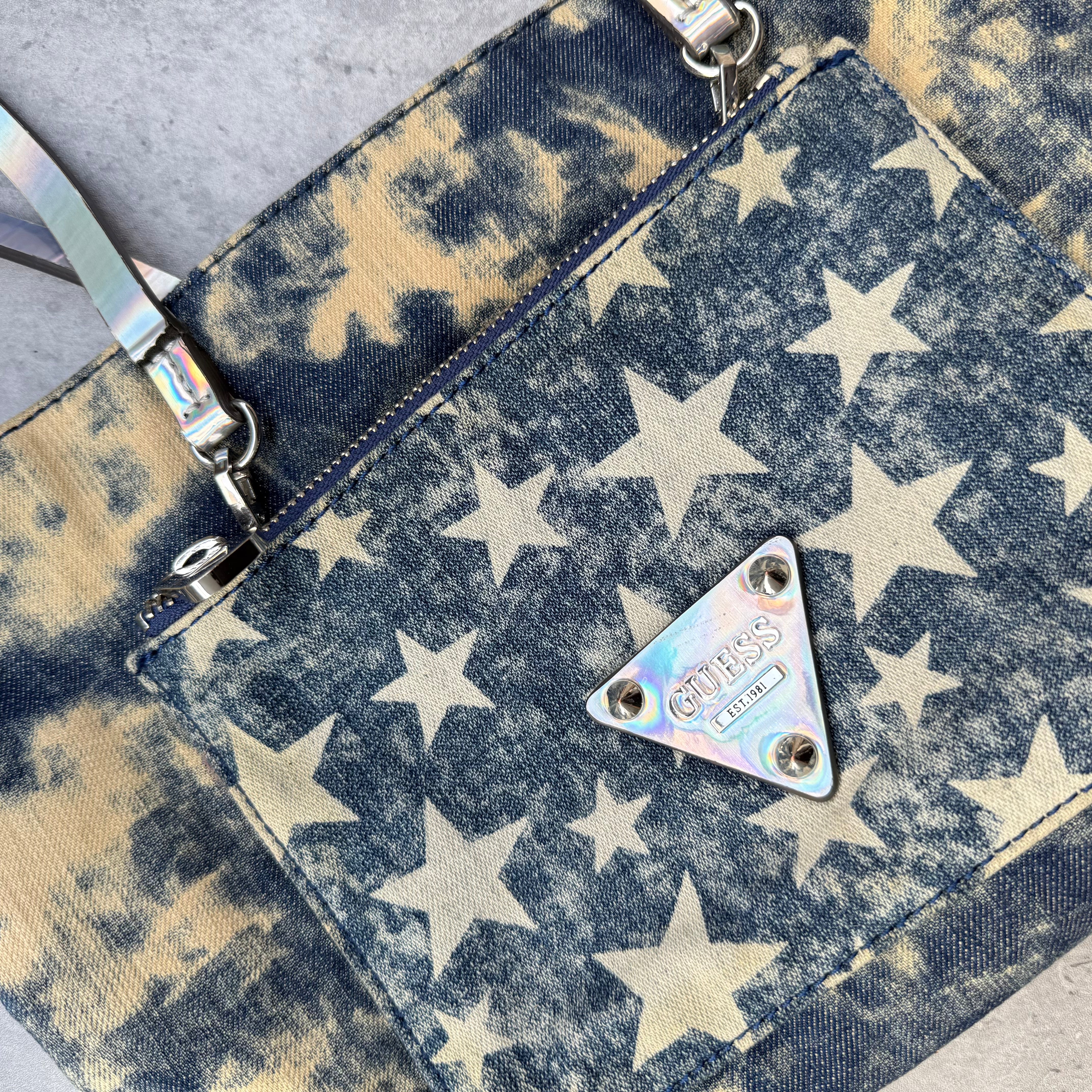 Guess Y2K Blue Denim Tote Bag with bleached star print, iridescent straps, red interior, and front Guess logo plaque.