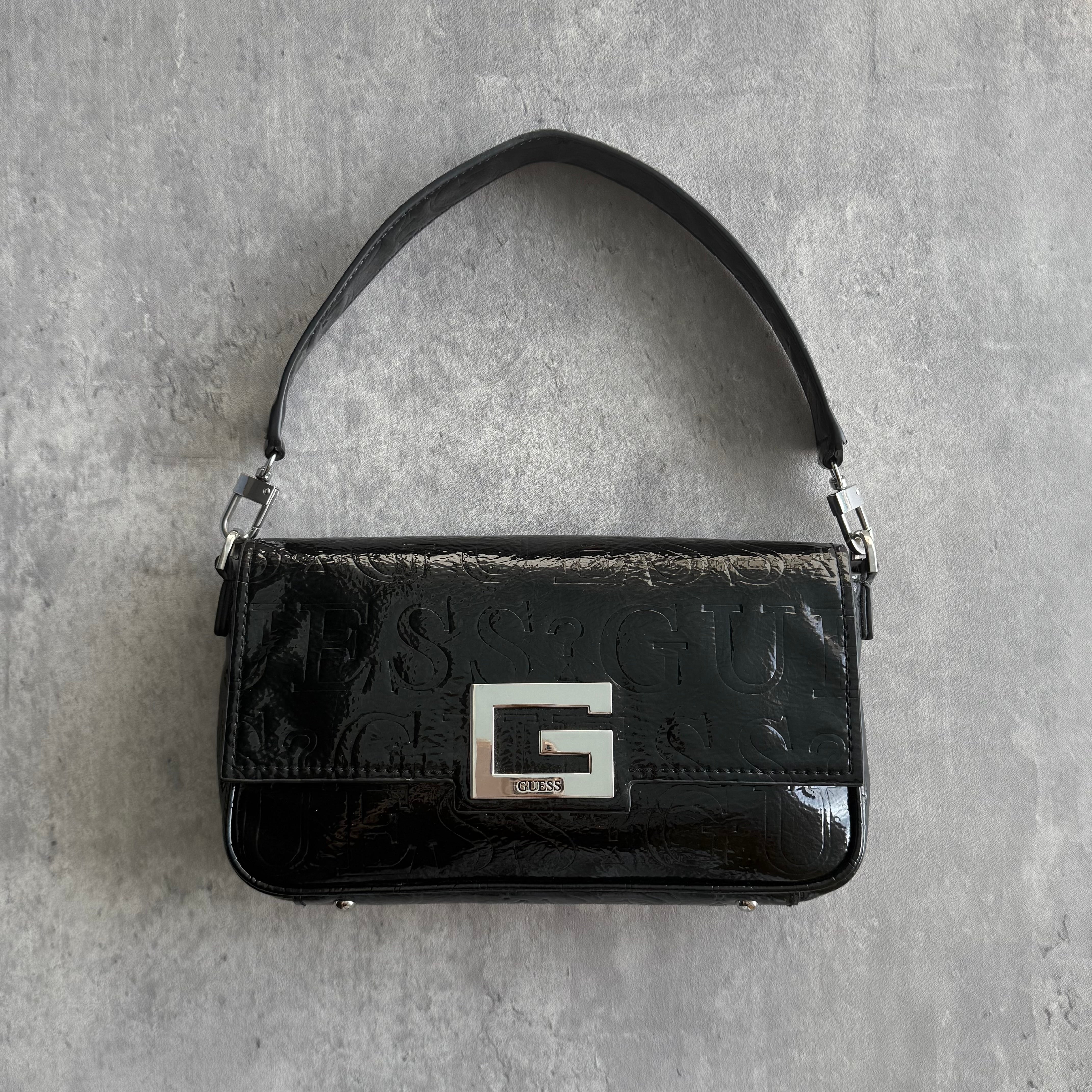 Guess Y2K black patent shoulder bag with embossed logo detailing, silver-tone G logo clasp, and monogram interior
