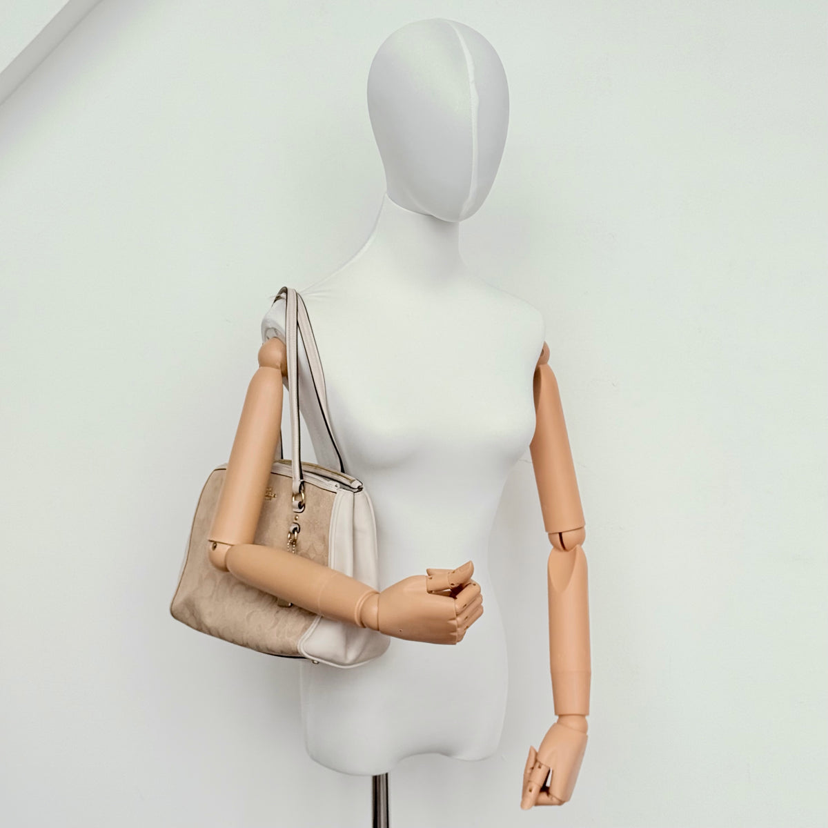 Coach Stanton Carryall in beige and ivory jacquard canvas with gold hardware and detachable strap, styled for everyday versatility.