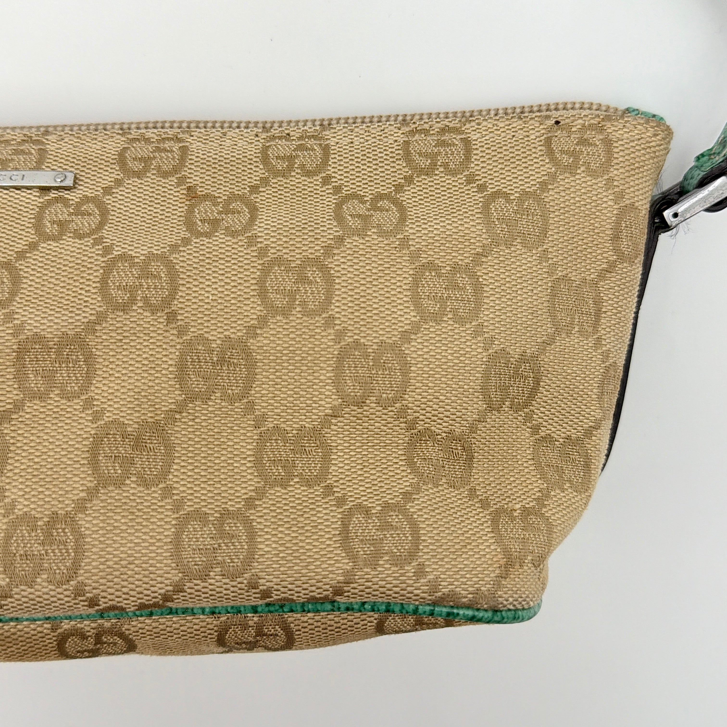 Gucci GG Monogram Pochette Boat Shoulder Bag in beige canvas with green leather trim and a structured, boat-shaped silhouette.