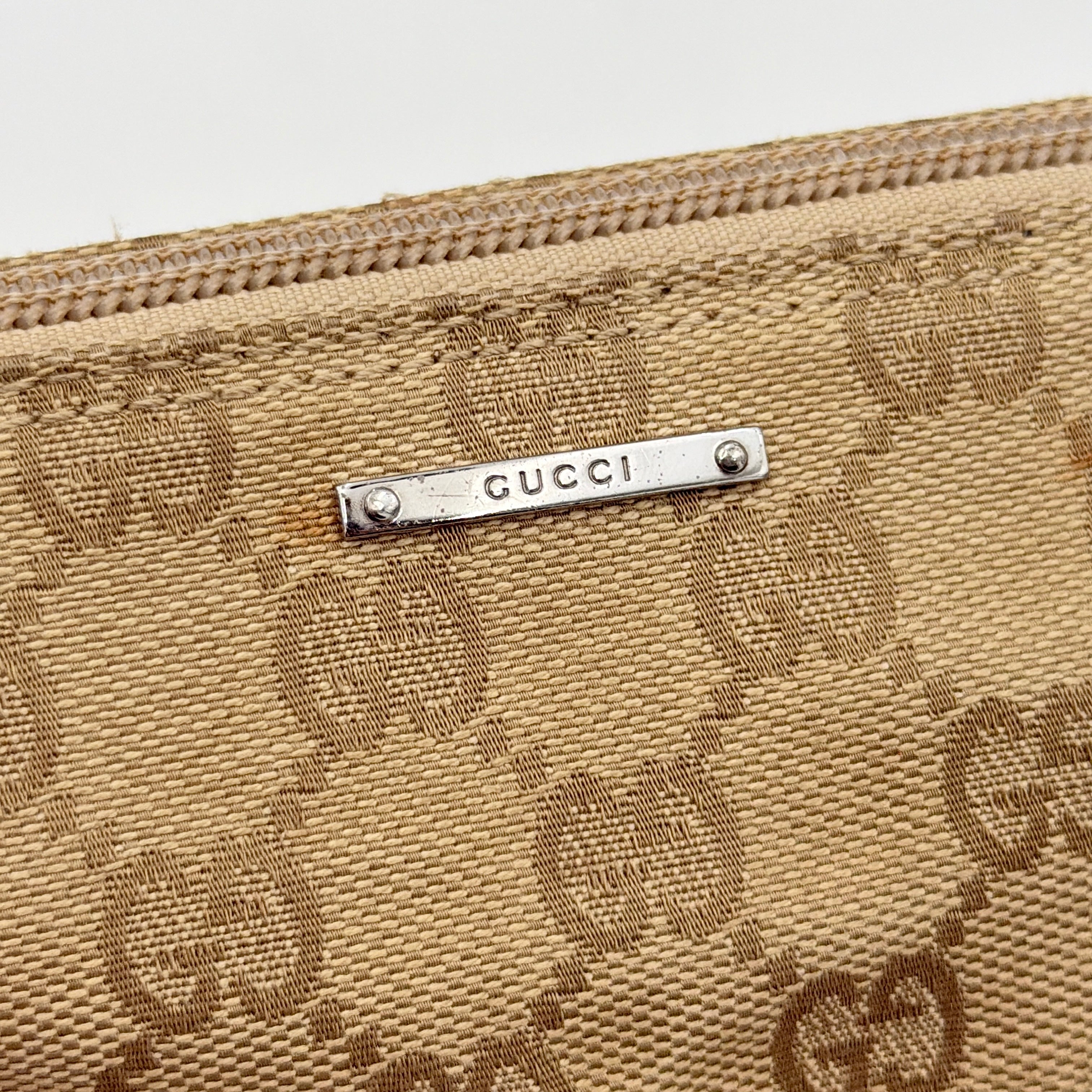 Gucci GG Monogram Pochette Boat Shoulder Bag in beige canvas with green leather trim and a structured, boat-shaped silhouette.