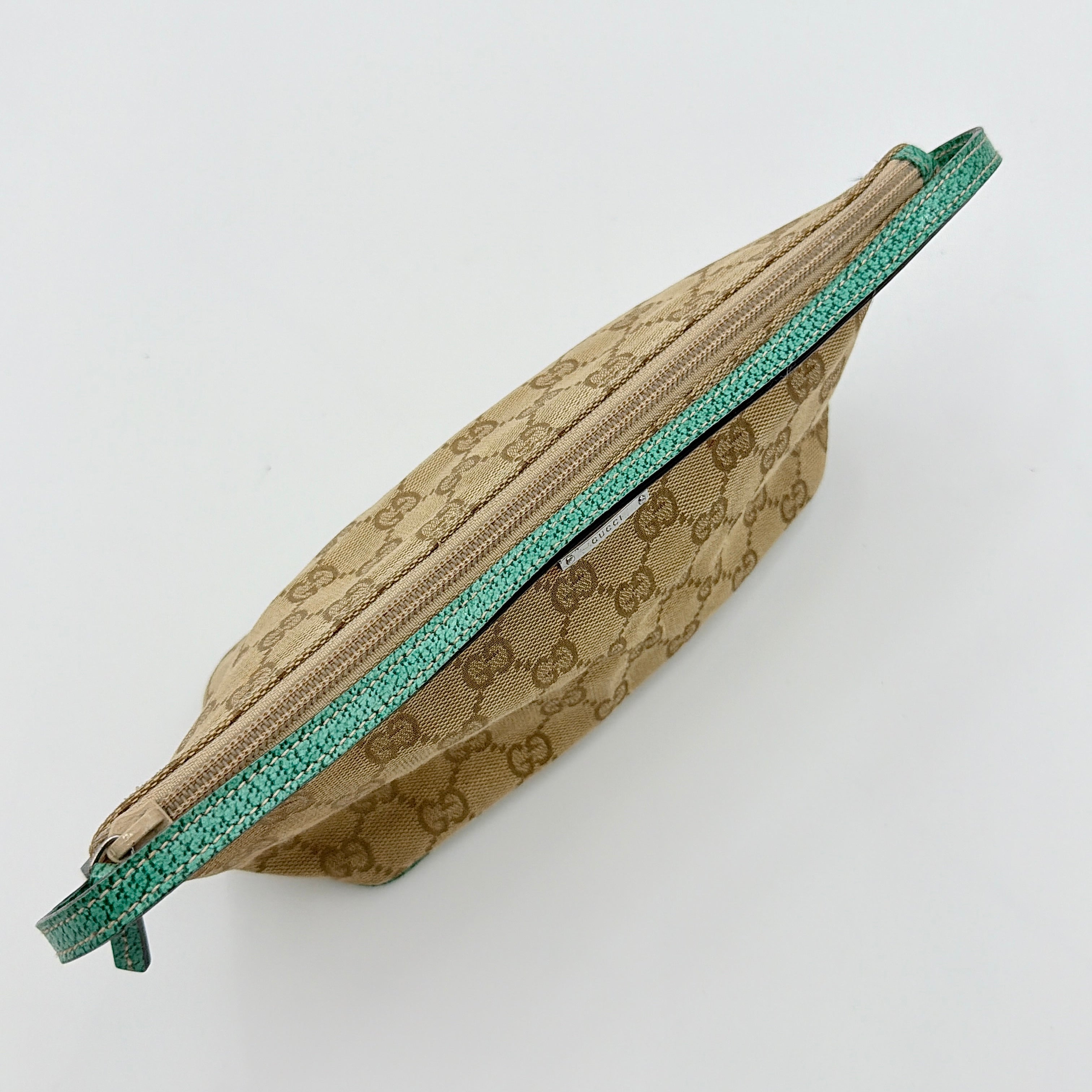 Gucci GG Monogram Pochette Boat Shoulder Bag in beige canvas with green leather trim and a structured, boat-shaped silhouette.