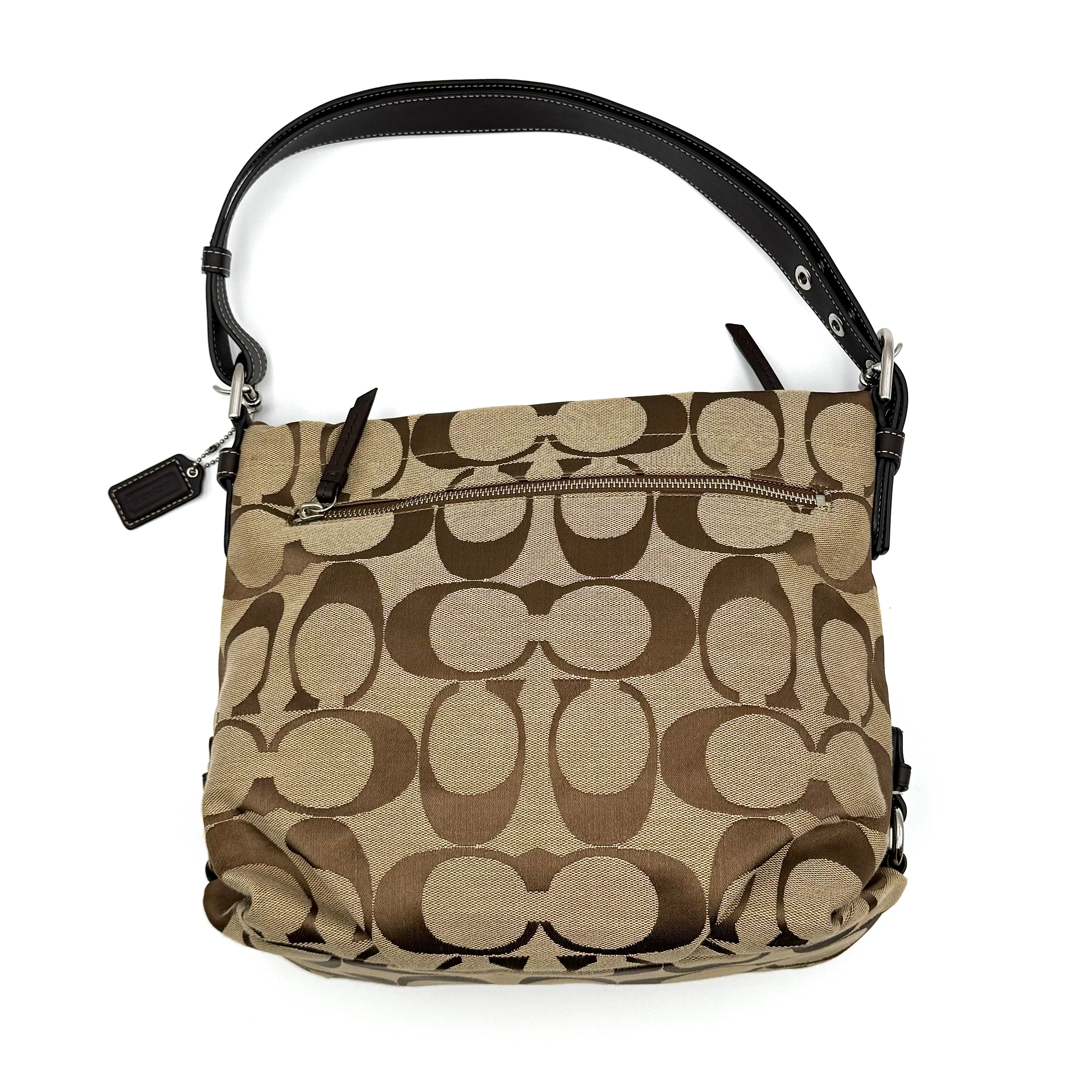 Coach beige and brown signature canvas hobo shoulder bag with black leather strap and silver hardware shown on a white background.