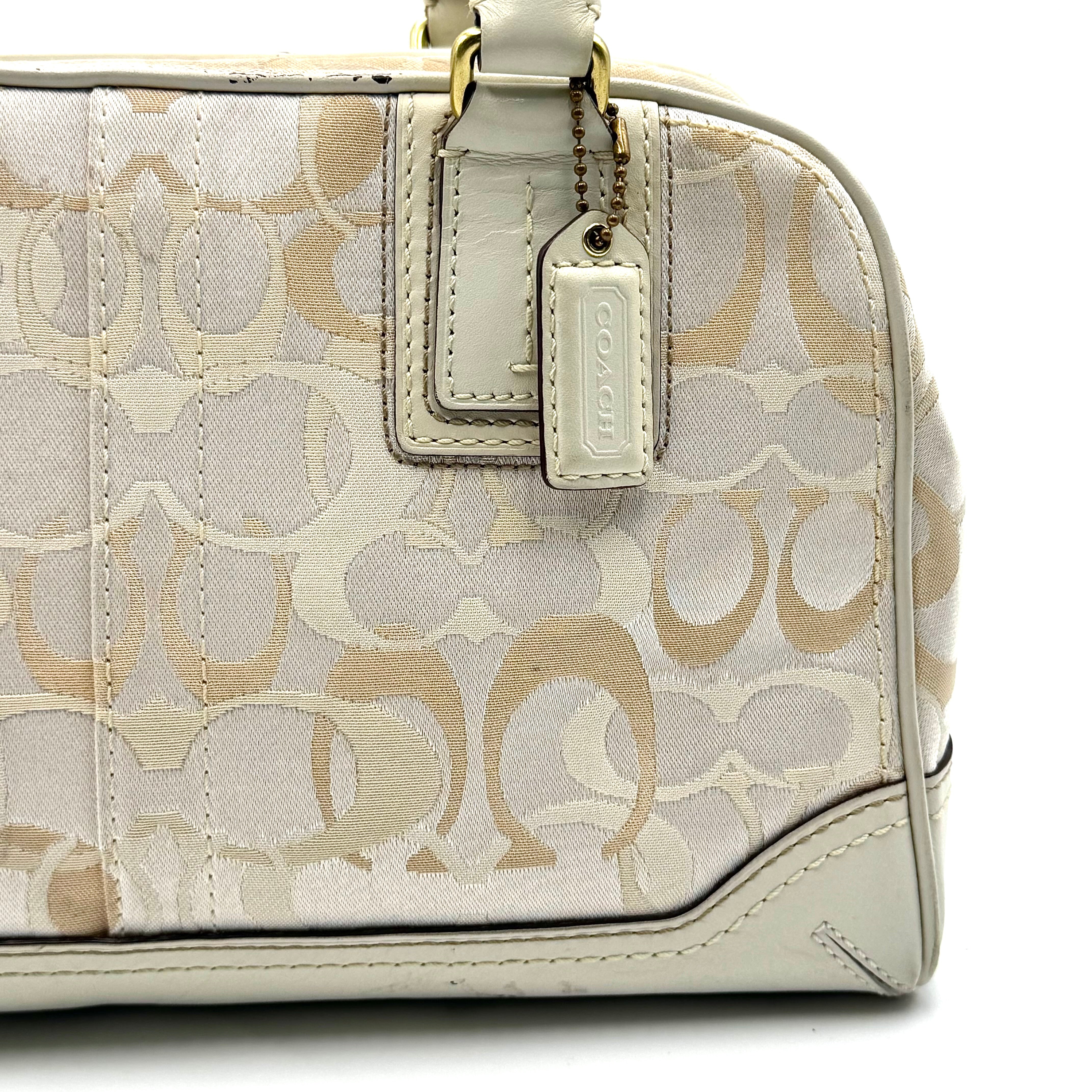 Coach Signature Canvas Satchel in ivory with dual rolled handles, monogram pattern and leather trim shown from the front against a clean background.