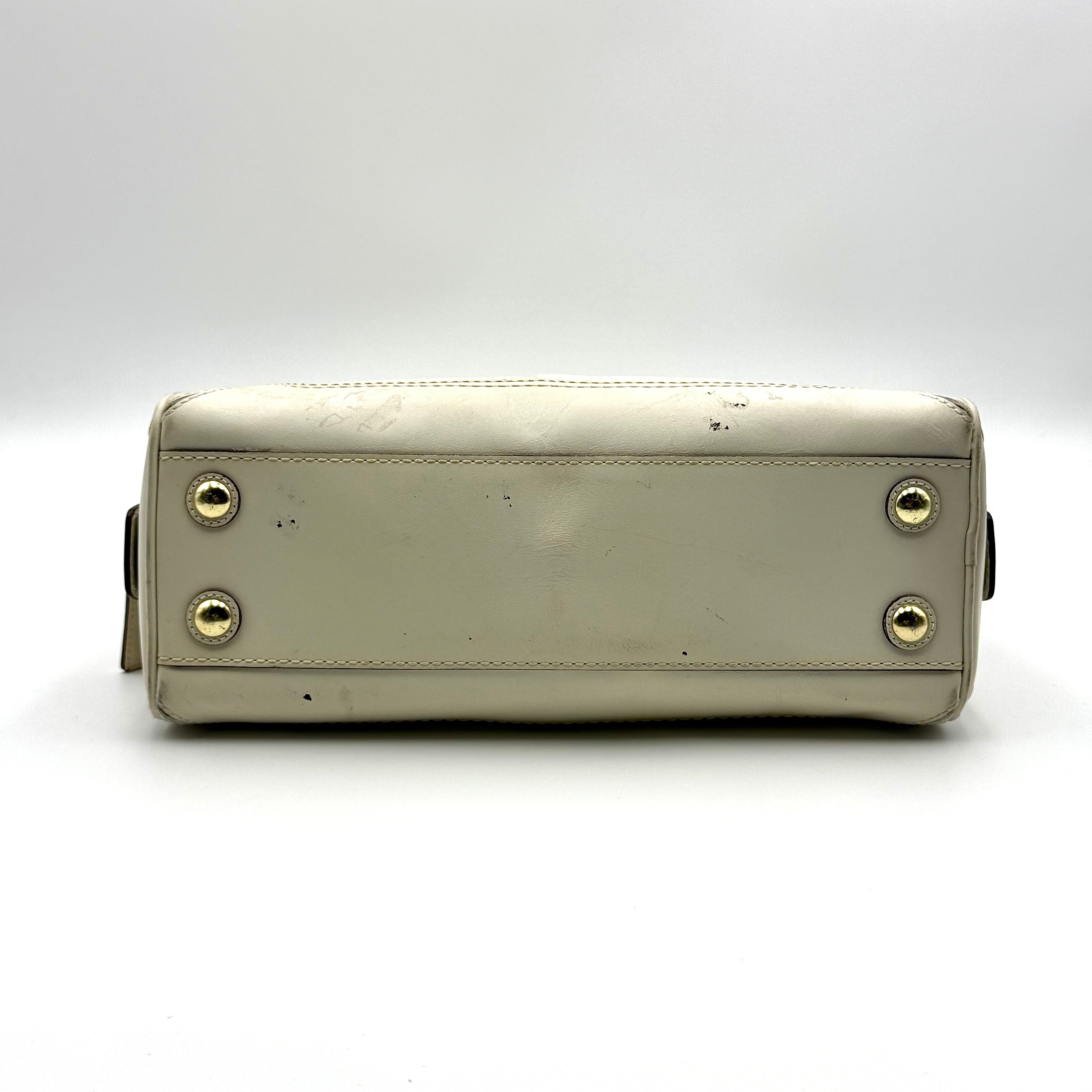 Coach Signature Canvas Satchel in ivory with dual rolled handles, monogram pattern and leather trim shown from the front against a clean background.