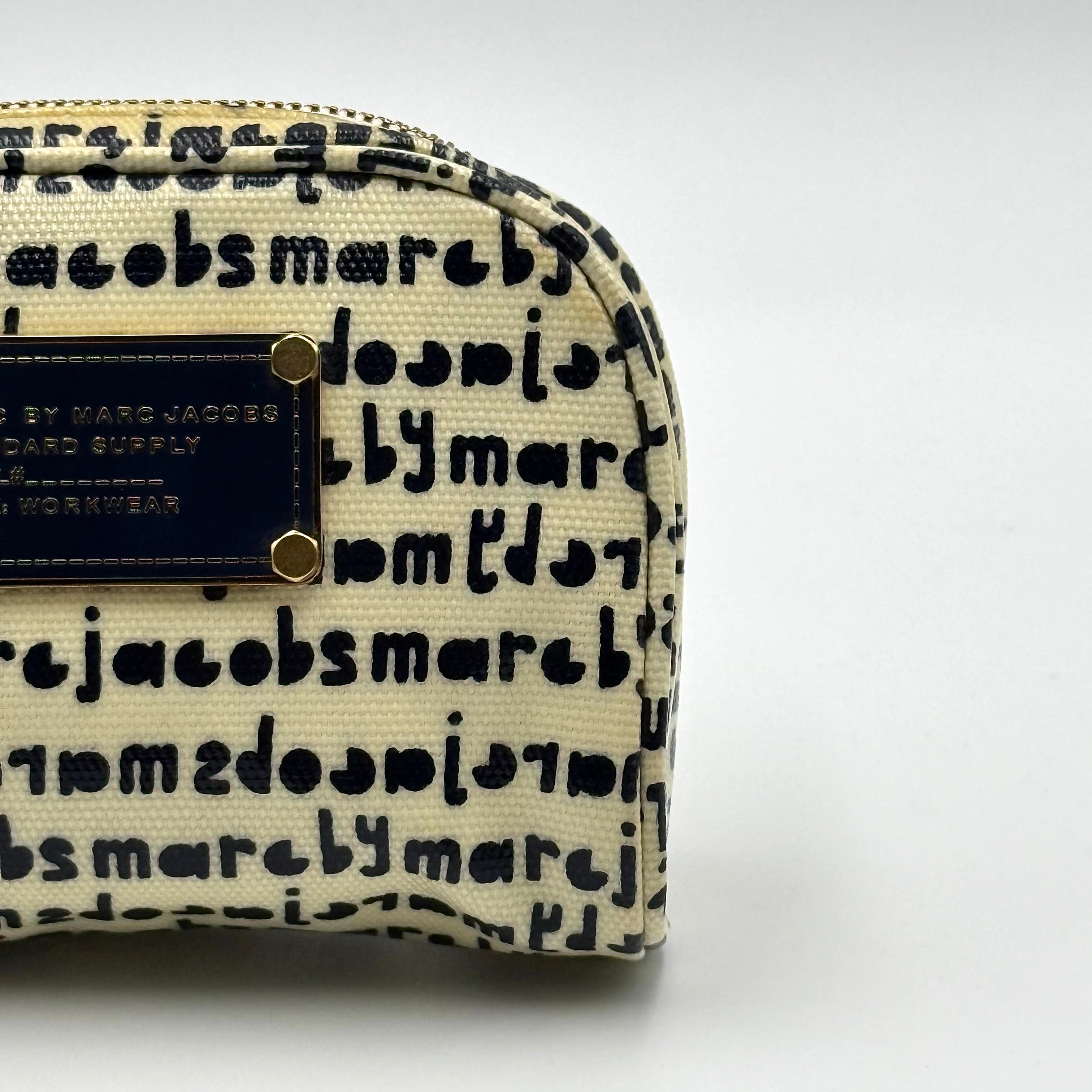 Marc Jacobs dome-shaped cosmetic case in cream coated canvas with navy script and gold hardware.