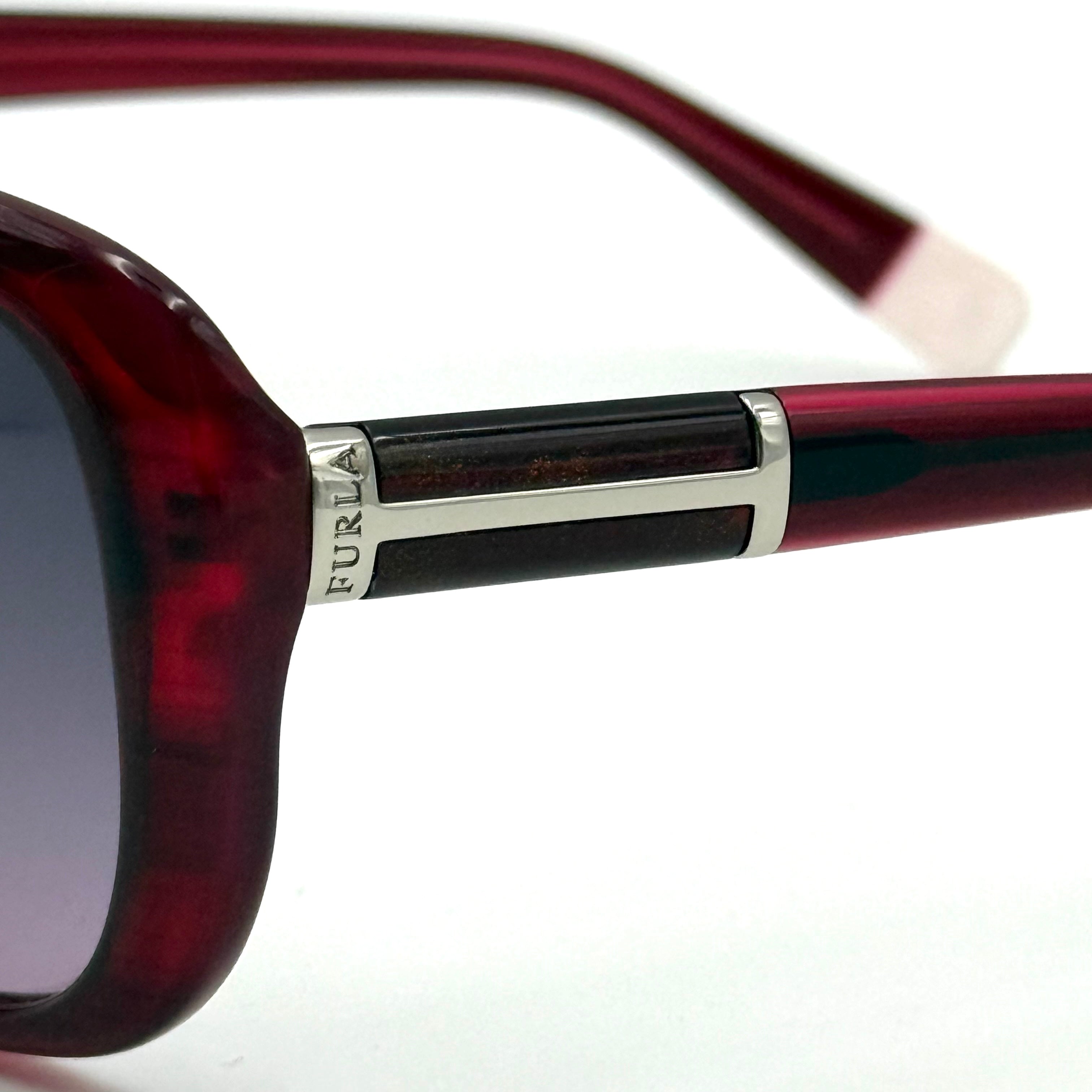 Furla SU4925J sunglasses in dark red acetate with butterfly-shaped frames, silver-tone hardware, and gradient lenses, presented alongside a Furla hard case.