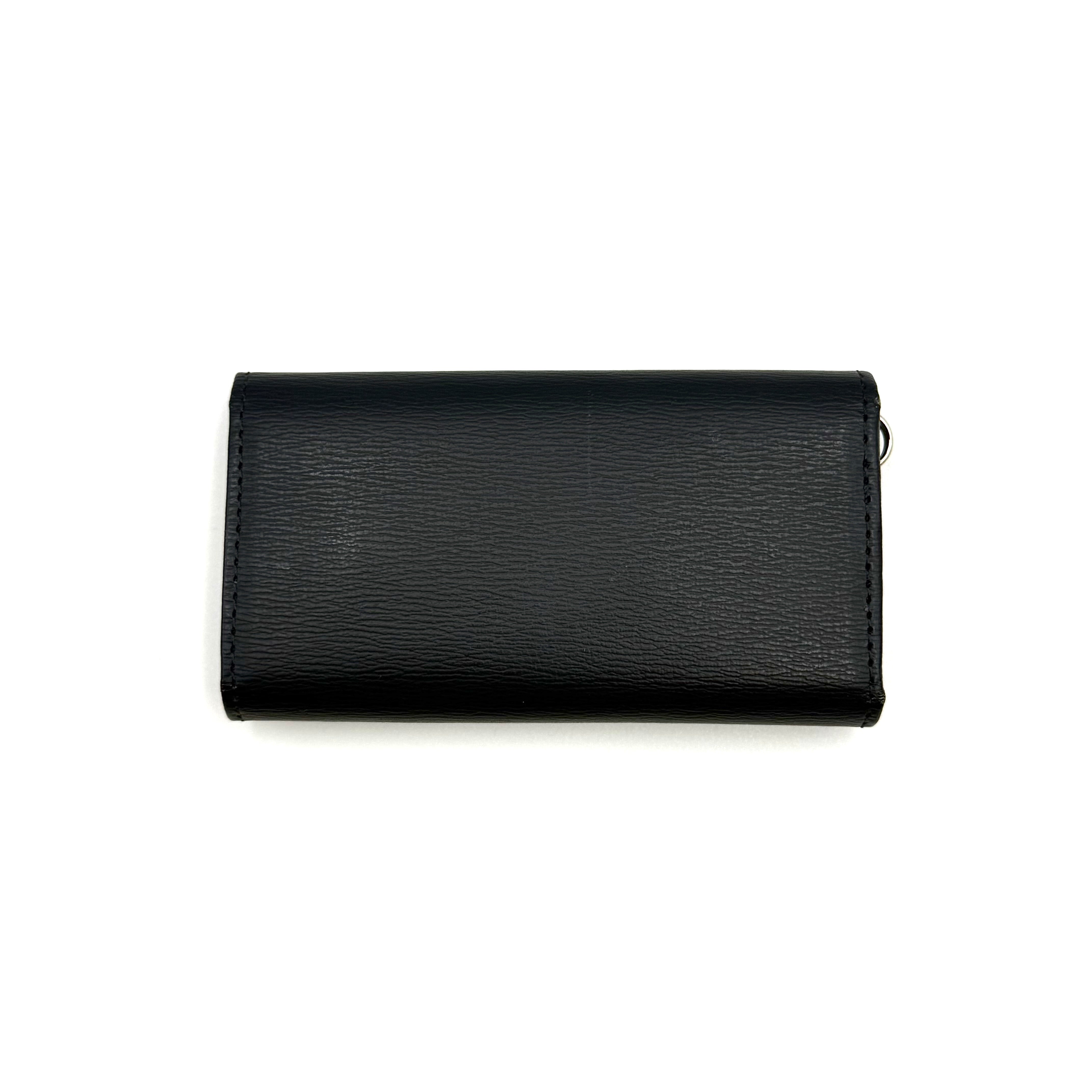 Paul Smith key case in grained black leather with Tiffany blue accents and silver logo, displayed on a white background.