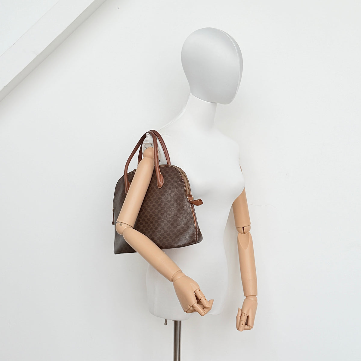 Celine Triomphe Macadam Dome Handbag in brown coated canvas with tan leather handles, shown against a white background.
