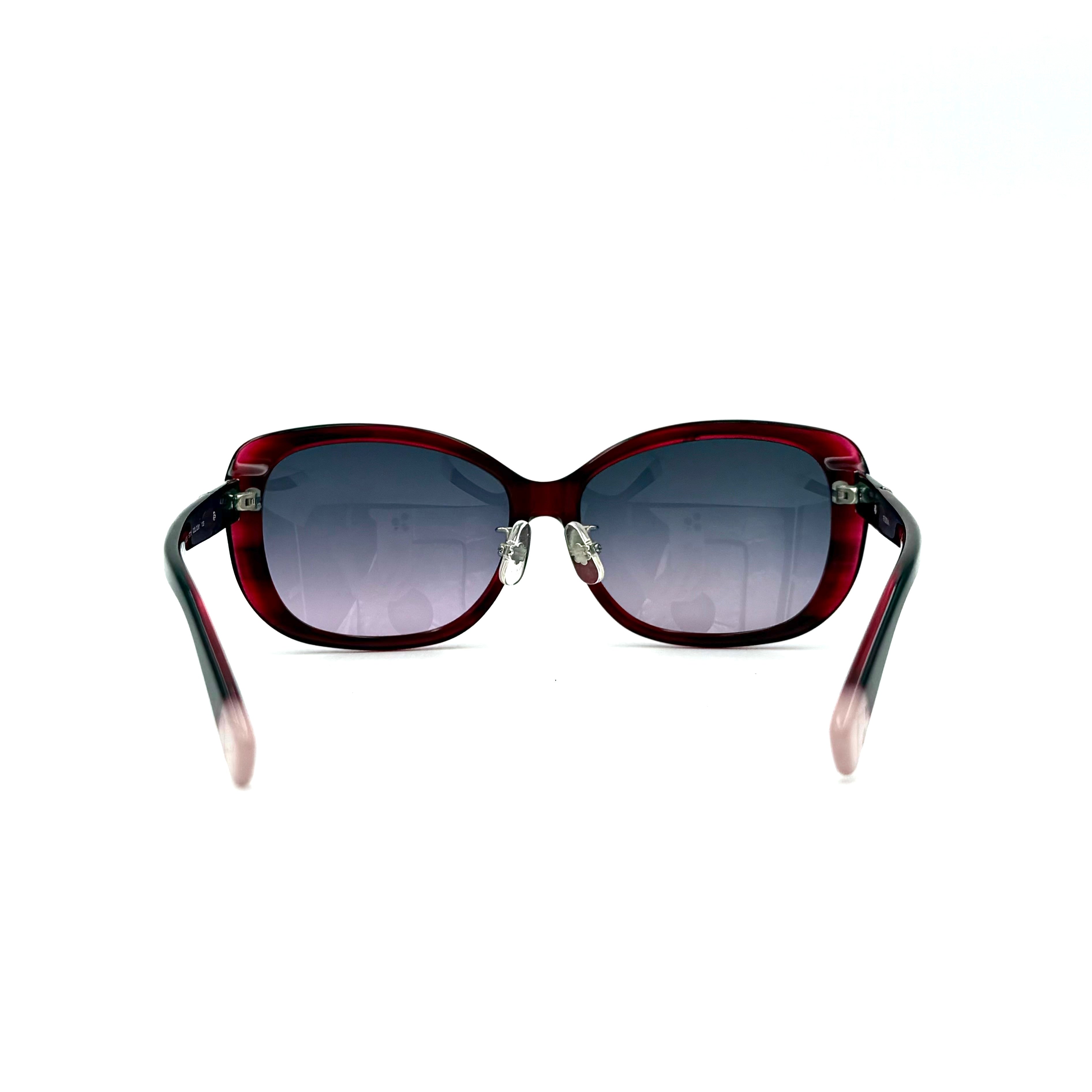 Furla SU4925J sunglasses in dark red acetate with butterfly-shaped frames, silver-tone hardware, and gradient lenses, presented alongside a Furla hard case.