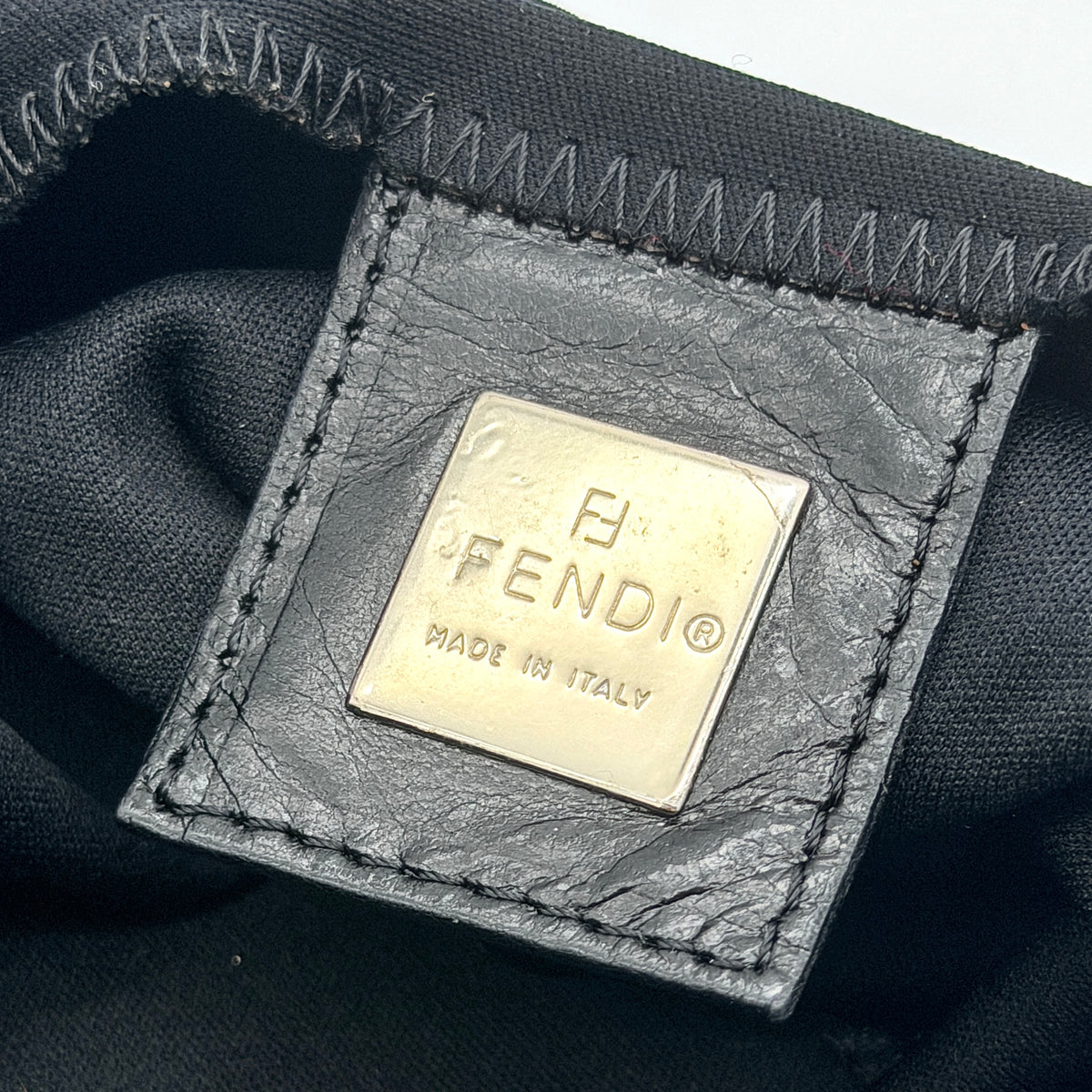 Fendi Mamma Baguette Shoulder Bag in black fabric with silver FF buckle and leather strap, photographed on a white backdrop.
