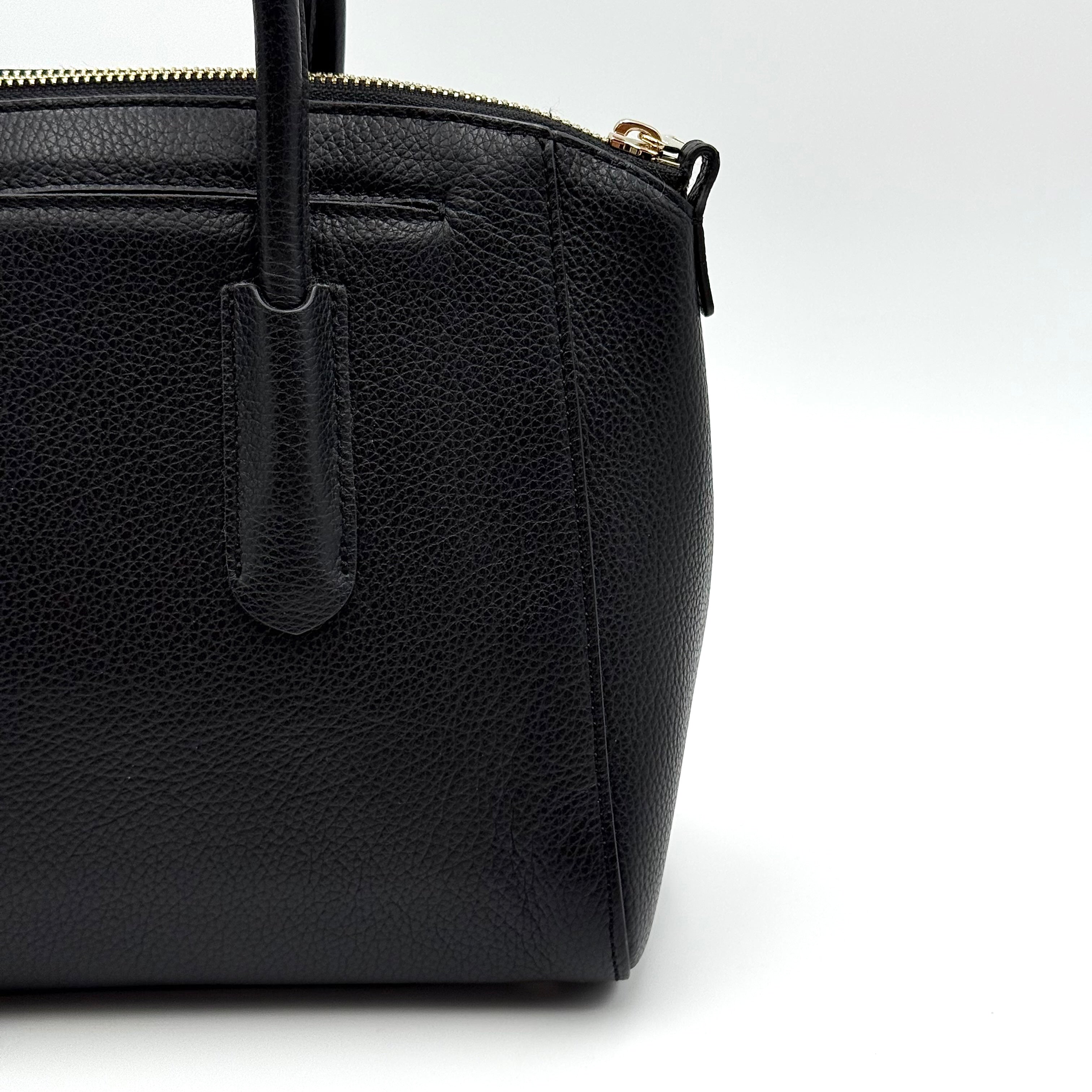 Front view of the Furla Tessa black leather satchel with gold-tone Furla charm and structured silhouette.