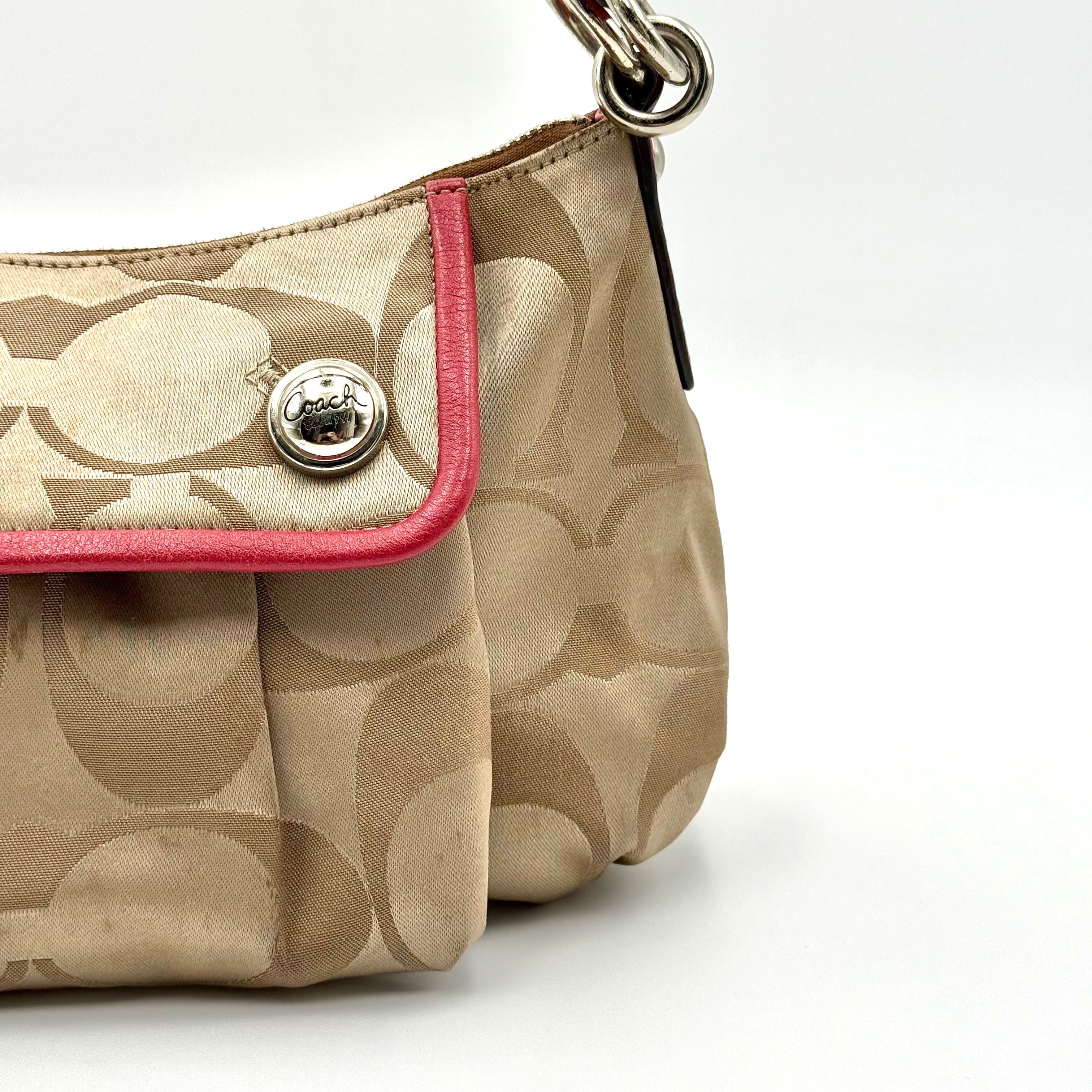 Coach Signature Poppy Sateen Groovy Shoulder Bag in beige with pink trim and detachable strap, displayed on a white background.