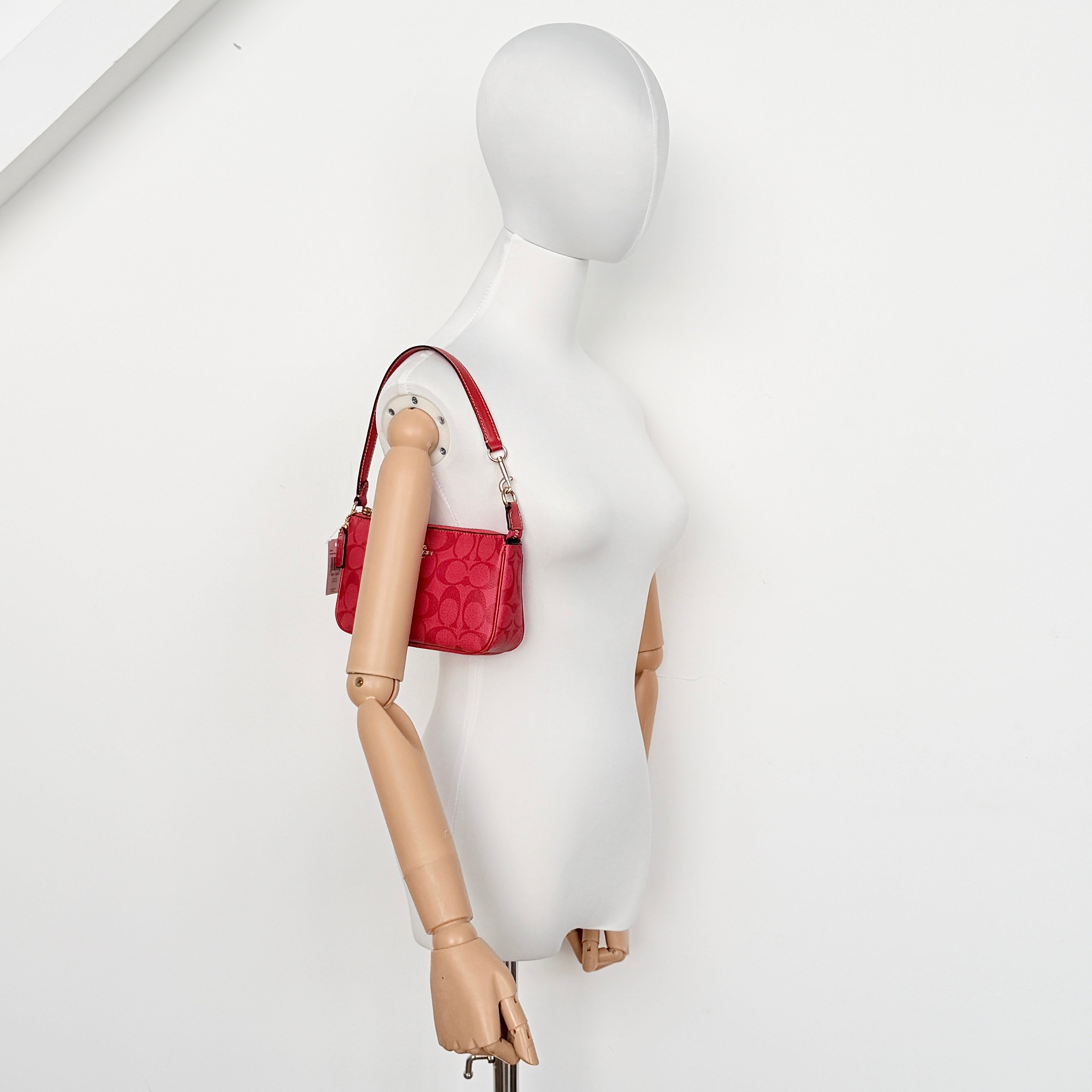 Coach Signature Nolita 19 Shoulder Bag in bright red coated canvas with signature pattern, gold-tone hardware and matching red hangtag.