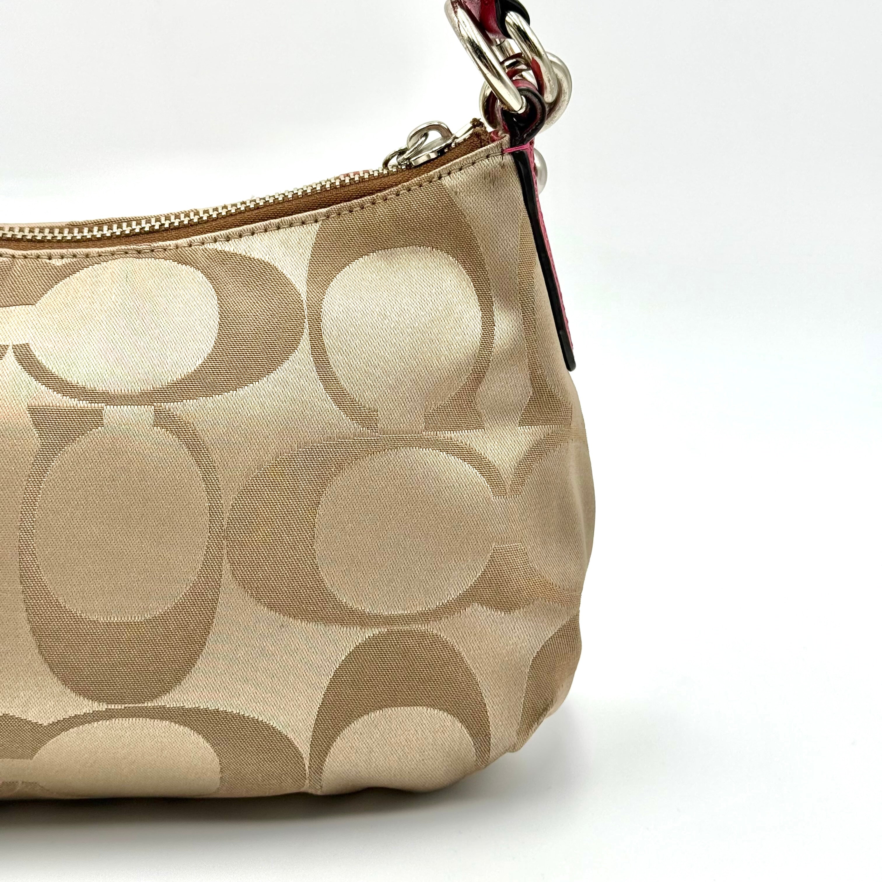 Coach Signature Poppy Sateen Groovy Shoulder Bag in beige with pink trim and detachable strap, displayed on a white background.