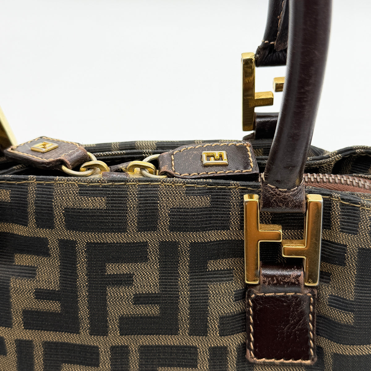 Fendi Zucca FF Monogram Handbag in brown canvas with leather handles and gold hardware, displayed against a clean background.