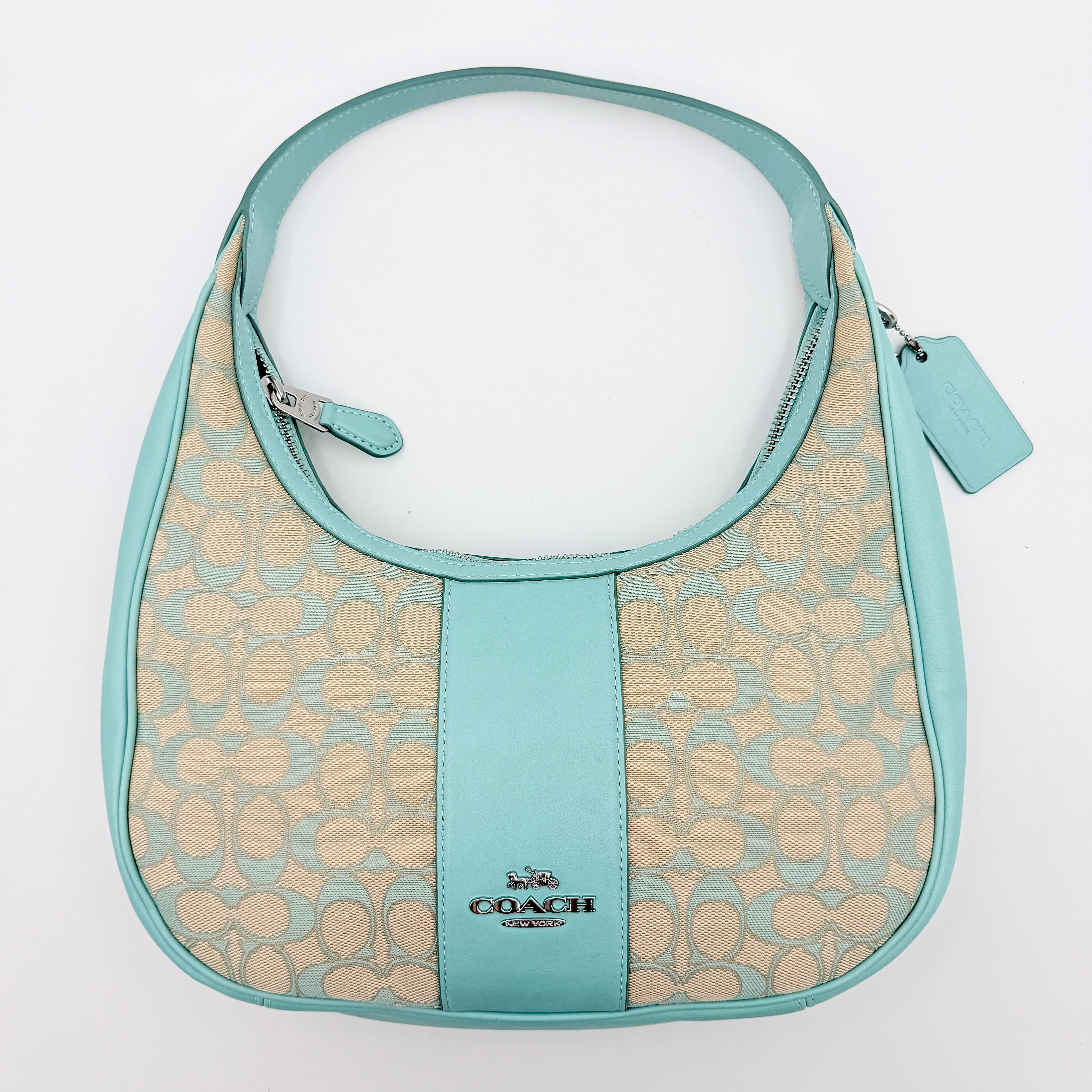 Coach Signature Carmen Shoulder Bag in beige and blue canvas with powder blue leather trim and silver hardware, photographed on white background.