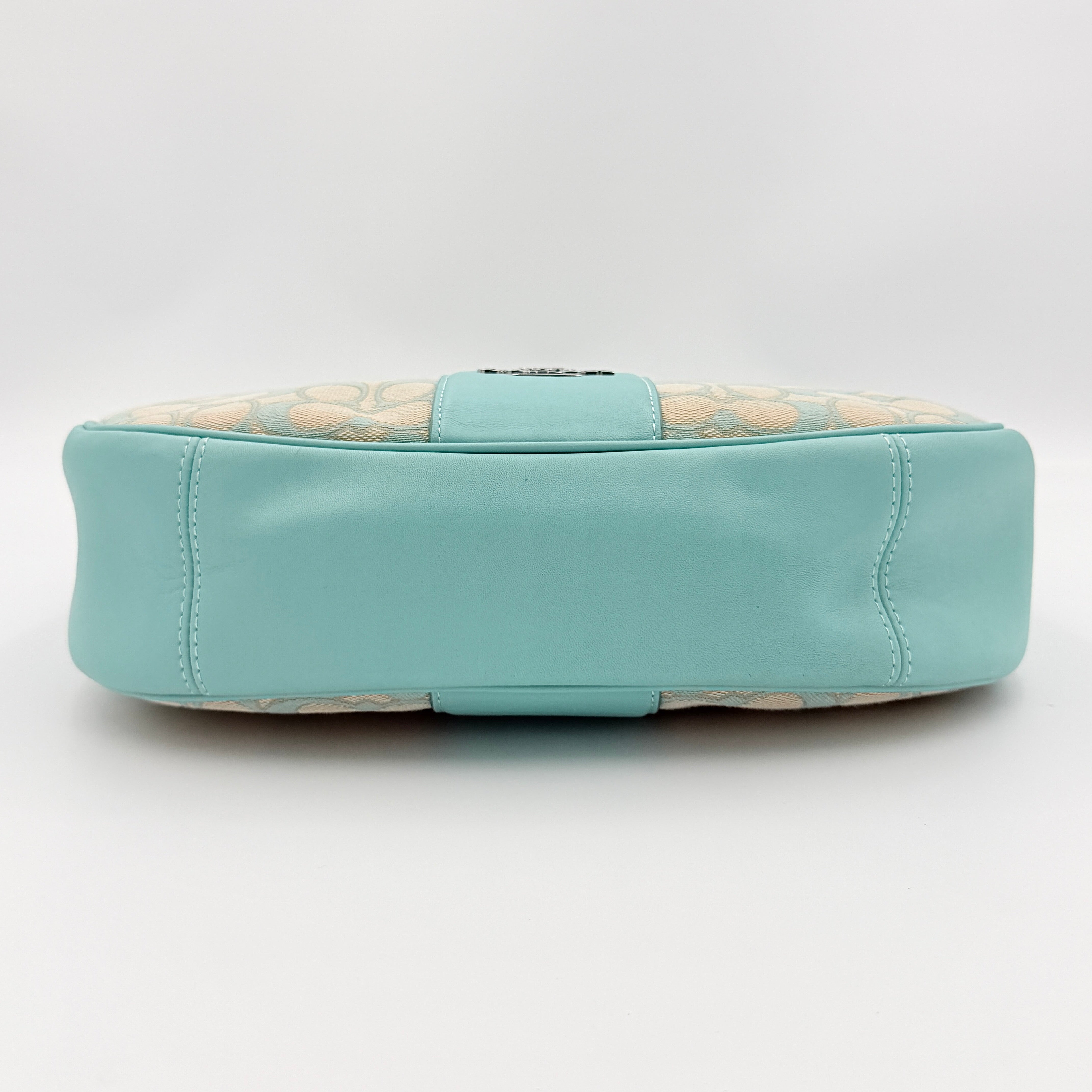Coach Signature Carmen Shoulder Bag in beige and blue canvas with powder blue leather trim and silver hardware, photographed on white background.