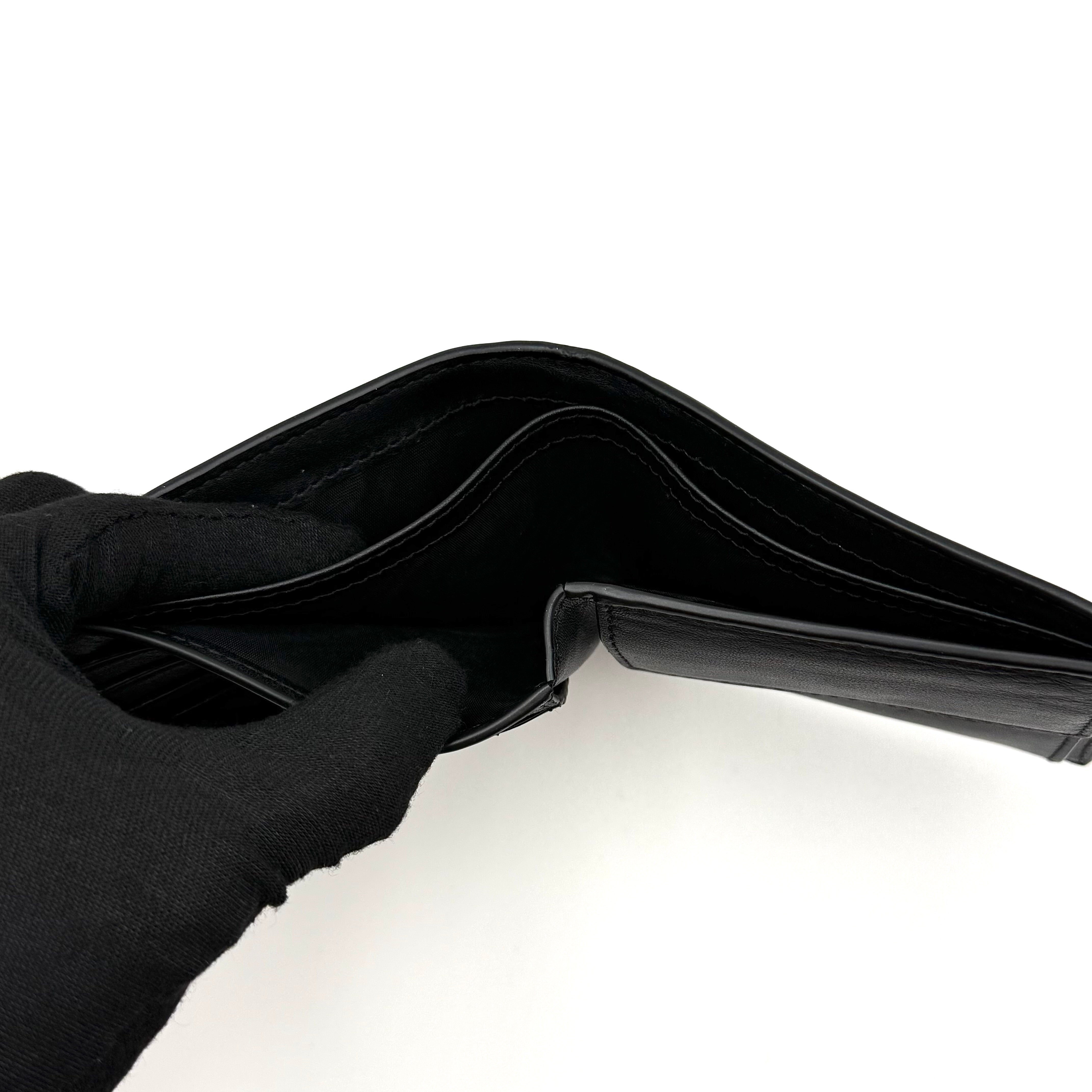 Furla Man Cosmo black leather bifold wallet with a textured teddy bear patch on the front.