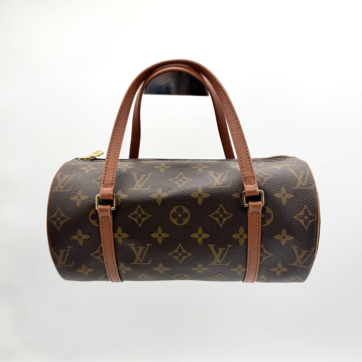 Louis Vuitton Papillon 26 in monogram canvas with leather handles and gold zipper, shown on a white background.