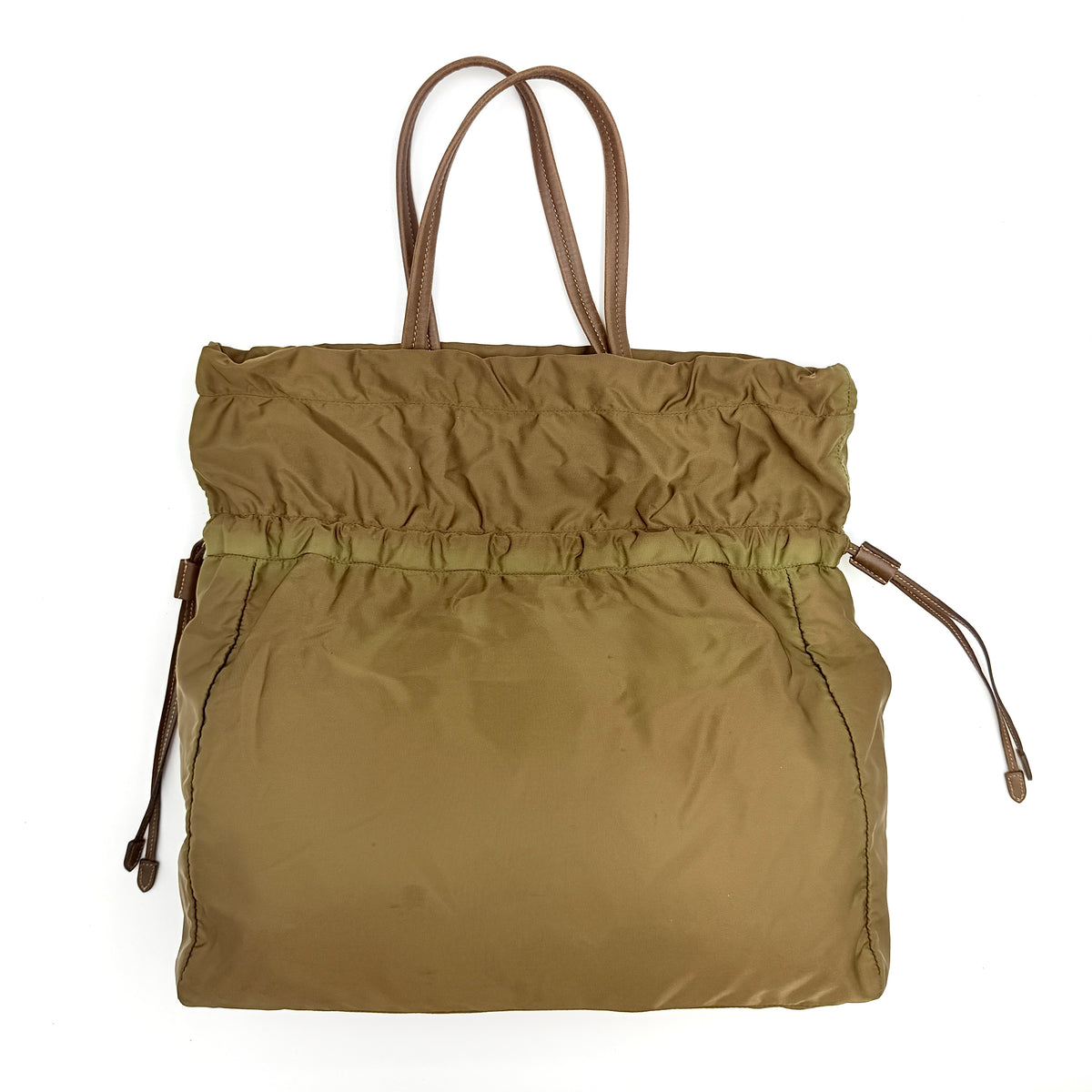 Prada Tessuto brown nylon drawstring shoulder bag with leather handles and gold logo detail, photographed against a white background.