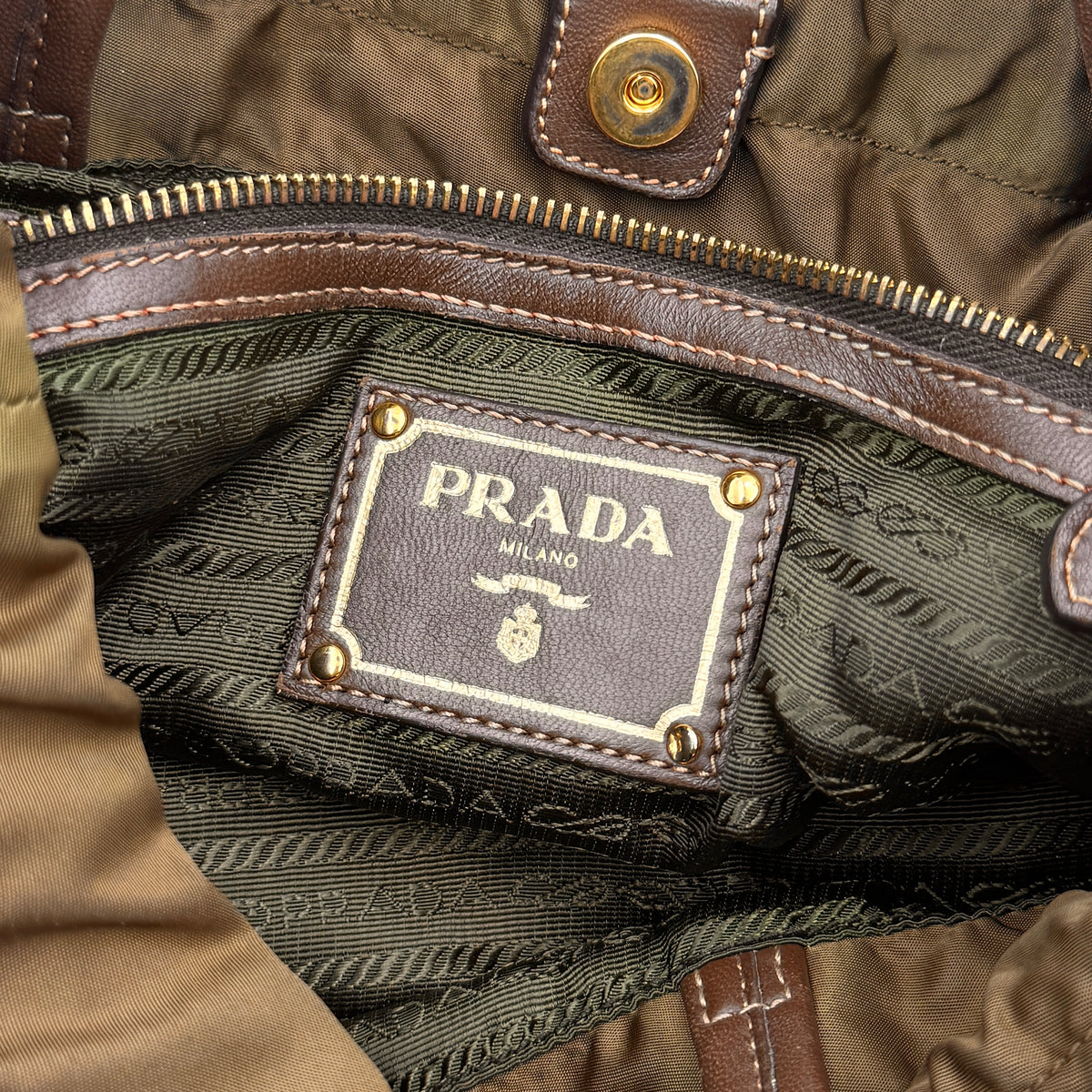 Prada Tessuto brown nylon drawstring shoulder bag with leather handles and gold logo detail, photographed against a white background.