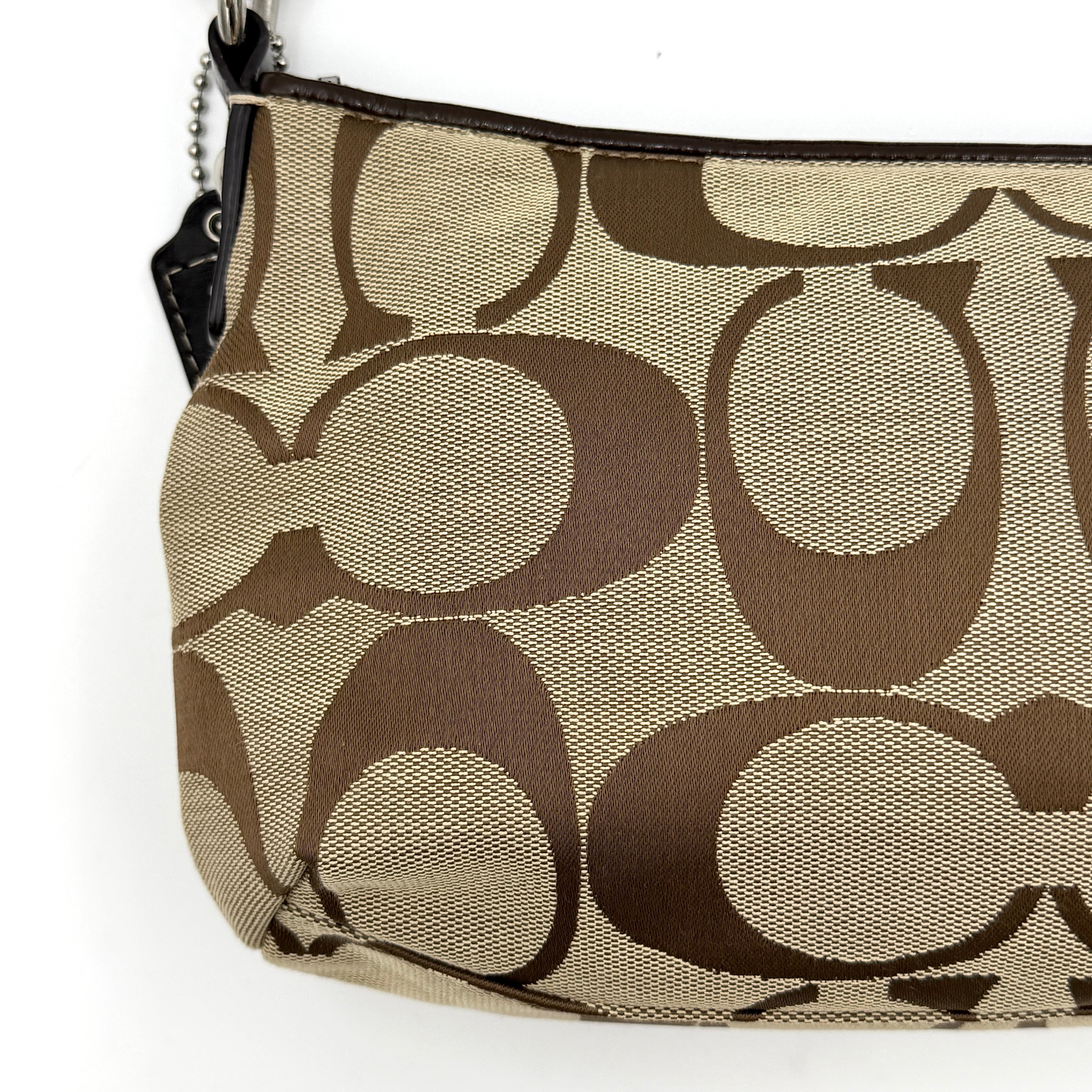 Coach khaki and mahogany signature jacquard shoulder bag with detachable strap and silver hardware displayed on a white background.