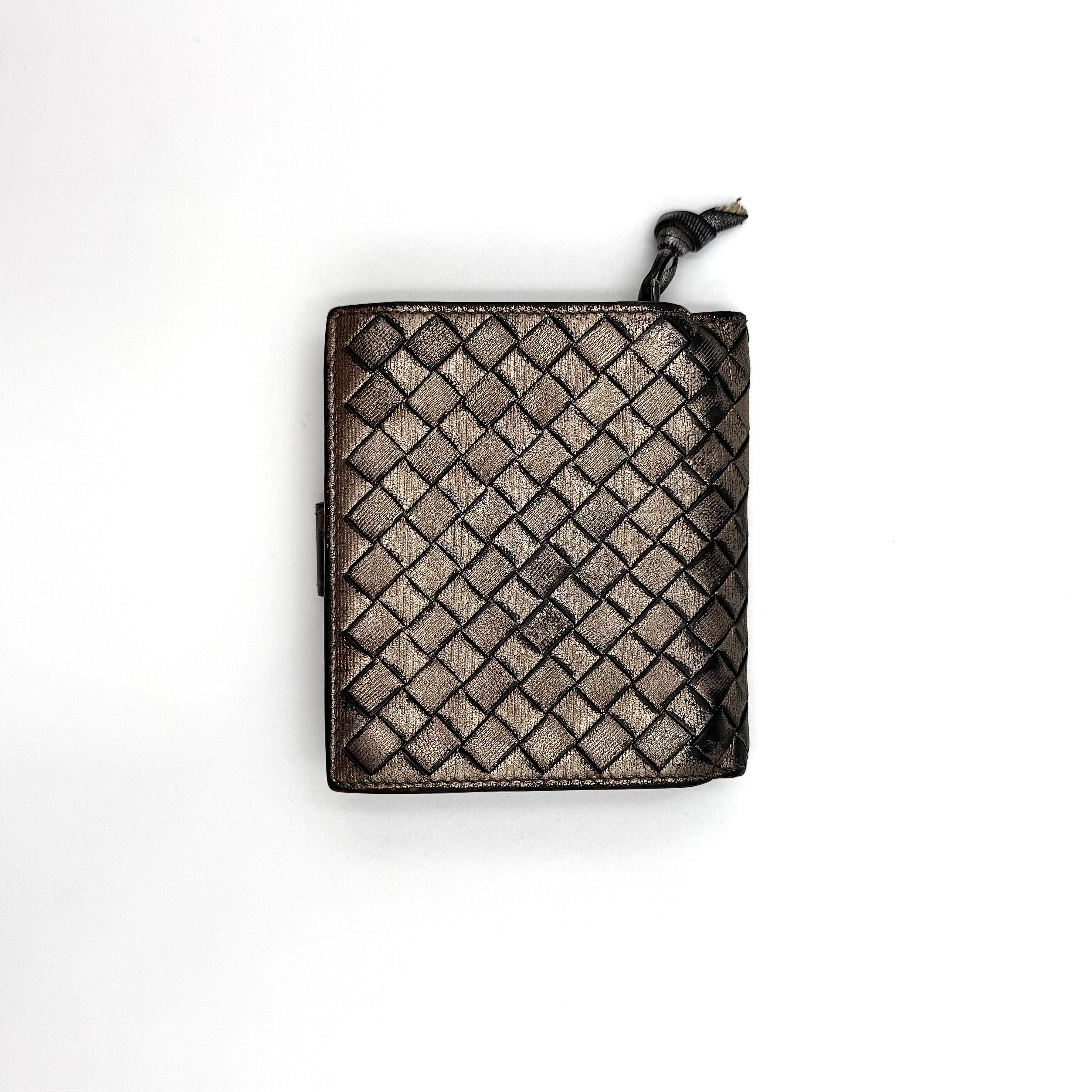 Bottega Veneta intrecciato metallic bronze leather wallet with snap tab and zip compartment.