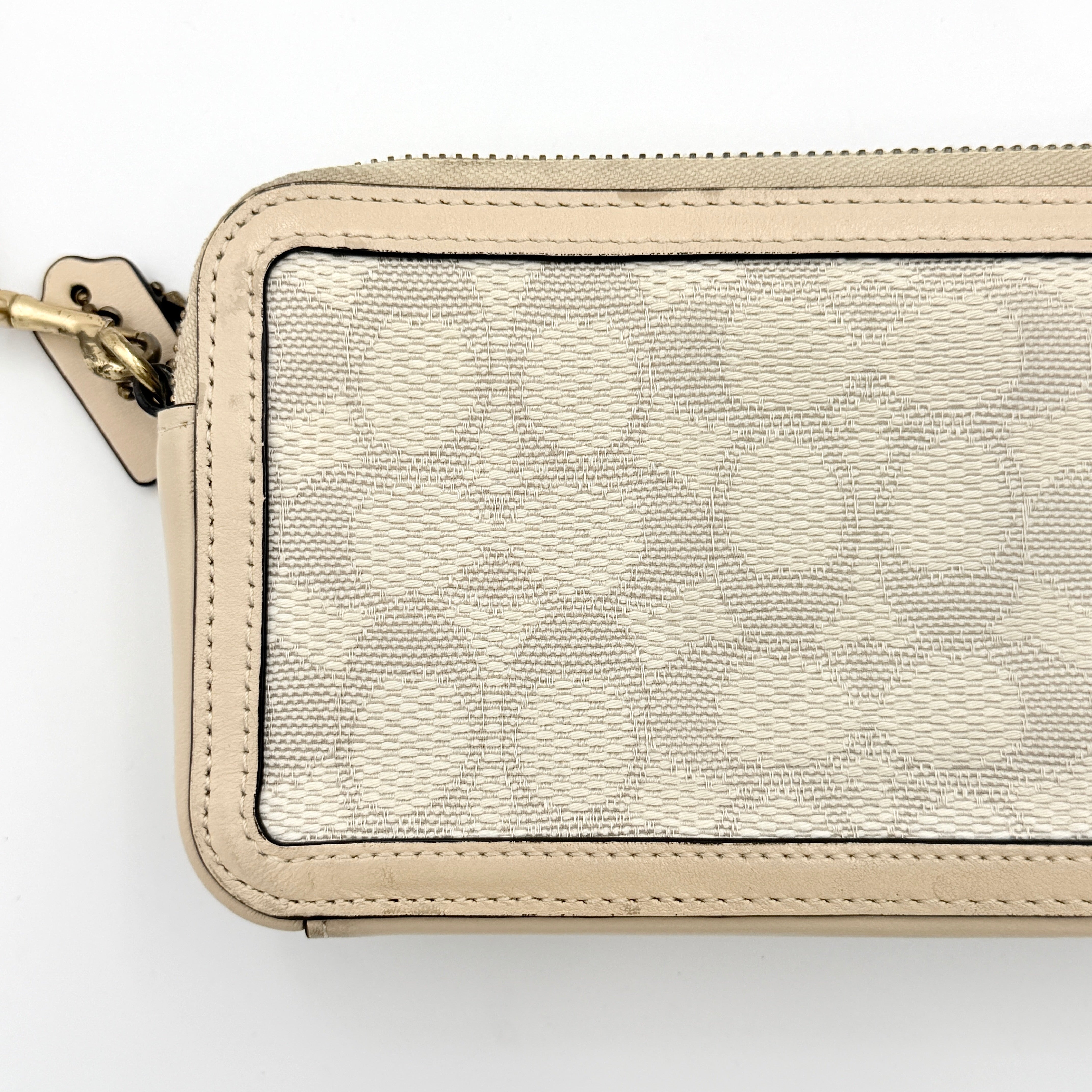 Coach Signature Kira Crossbody Bag in beige and white jacquard with leather trim and adjustable strap displayed against a white background.