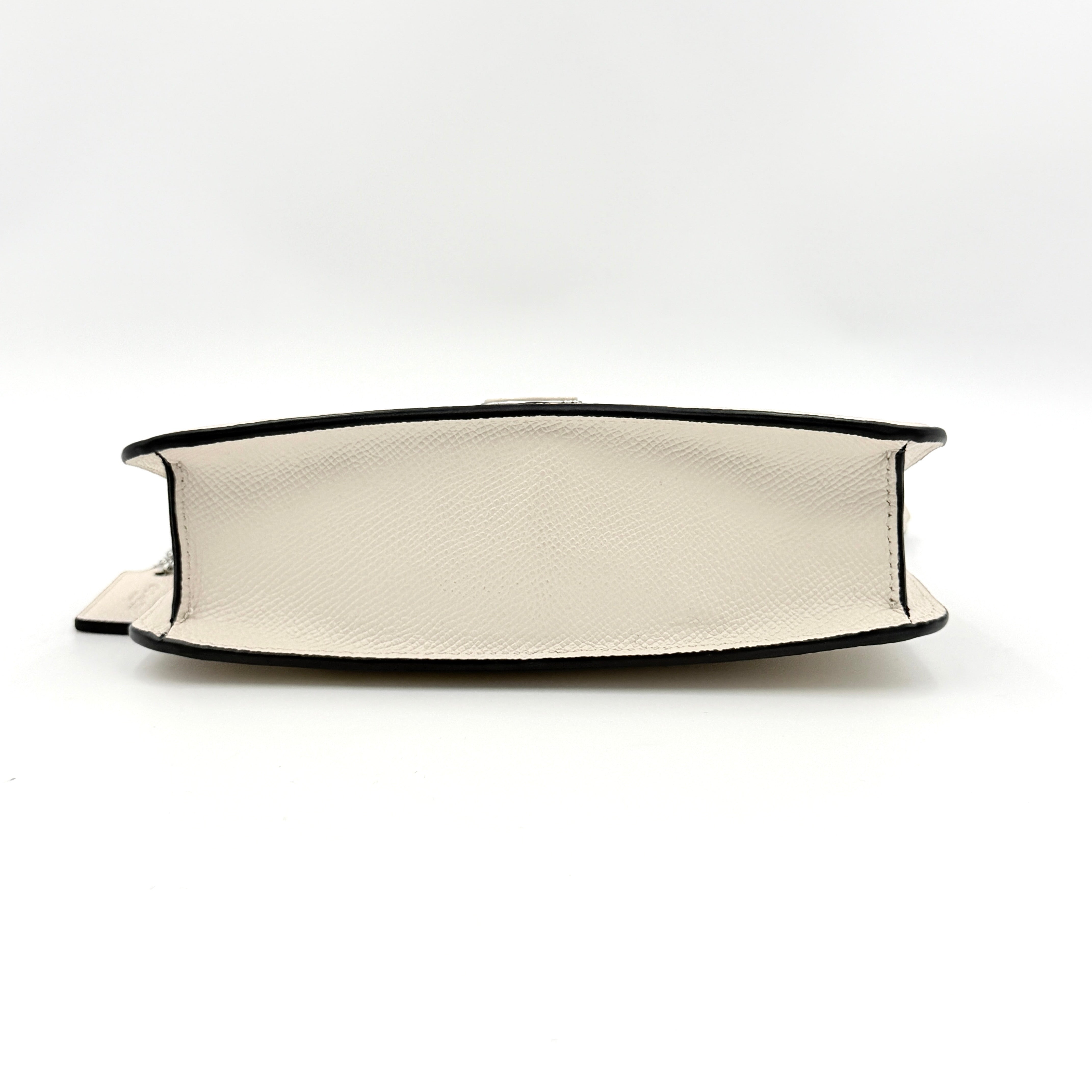 Coach cream grained leather shoulder bag with silver logo plaque and structured handle, displayed against a white background.