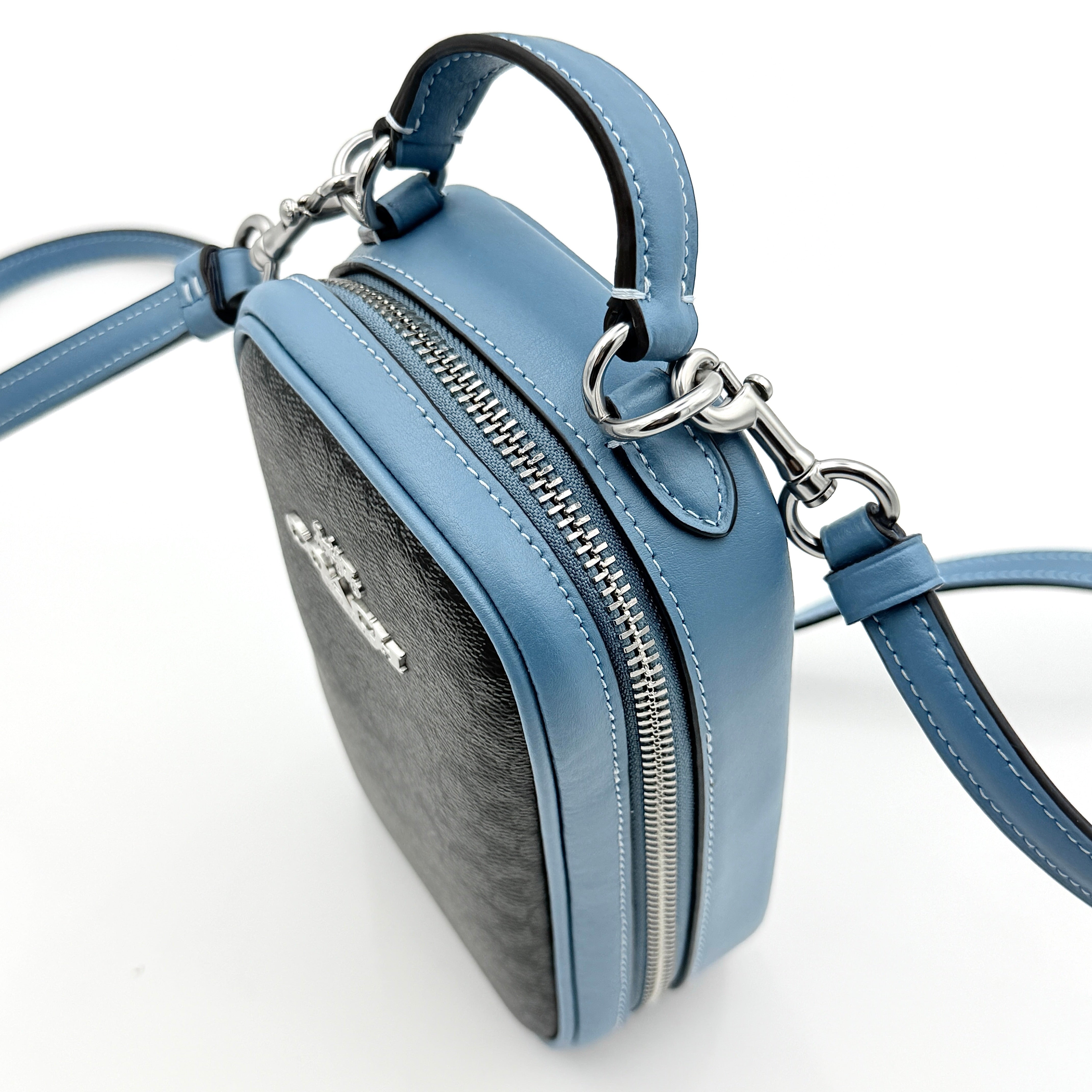 Coach Signature Eva Phone Crossbody in black coated canvas with blue leather trim and silver hardware displayed with its crossbody strap.