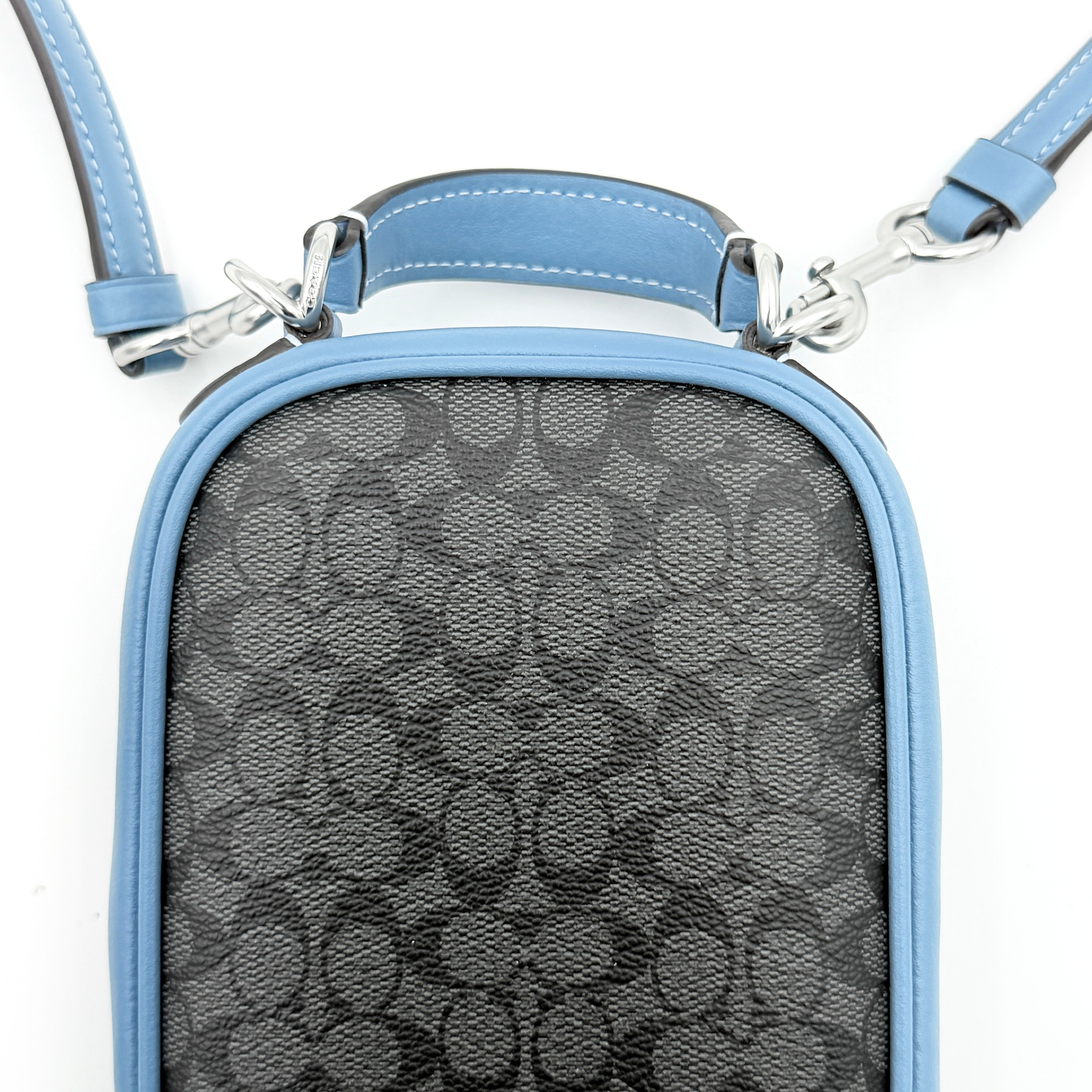 Coach Signature Eva Phone Crossbody in black coated canvas with blue leather trim and silver hardware displayed with its crossbody strap.