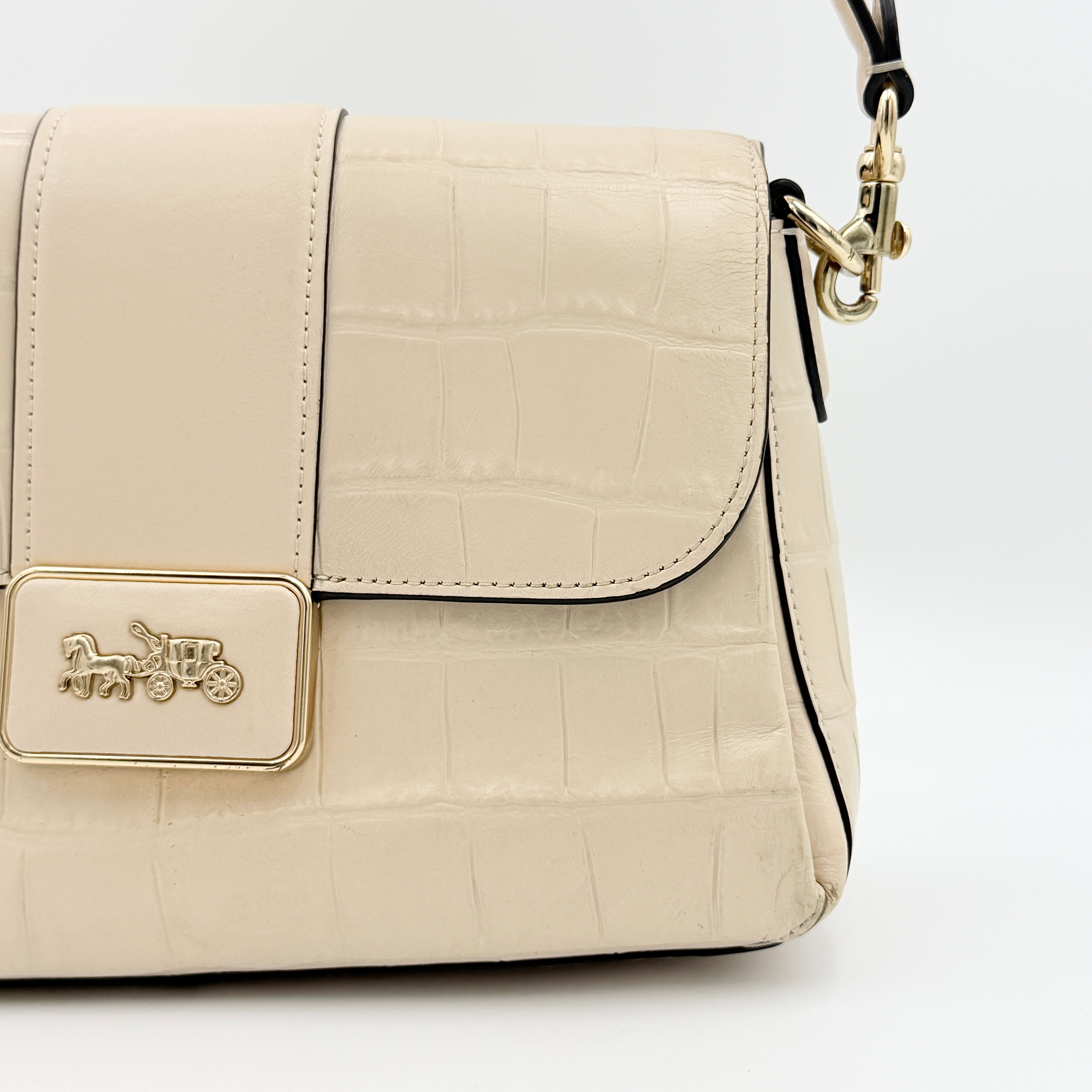 Coach Grace Shoulder Bag in ivory croc-embossed leather with gold-tone carriage plaque and structured shoulder strap.