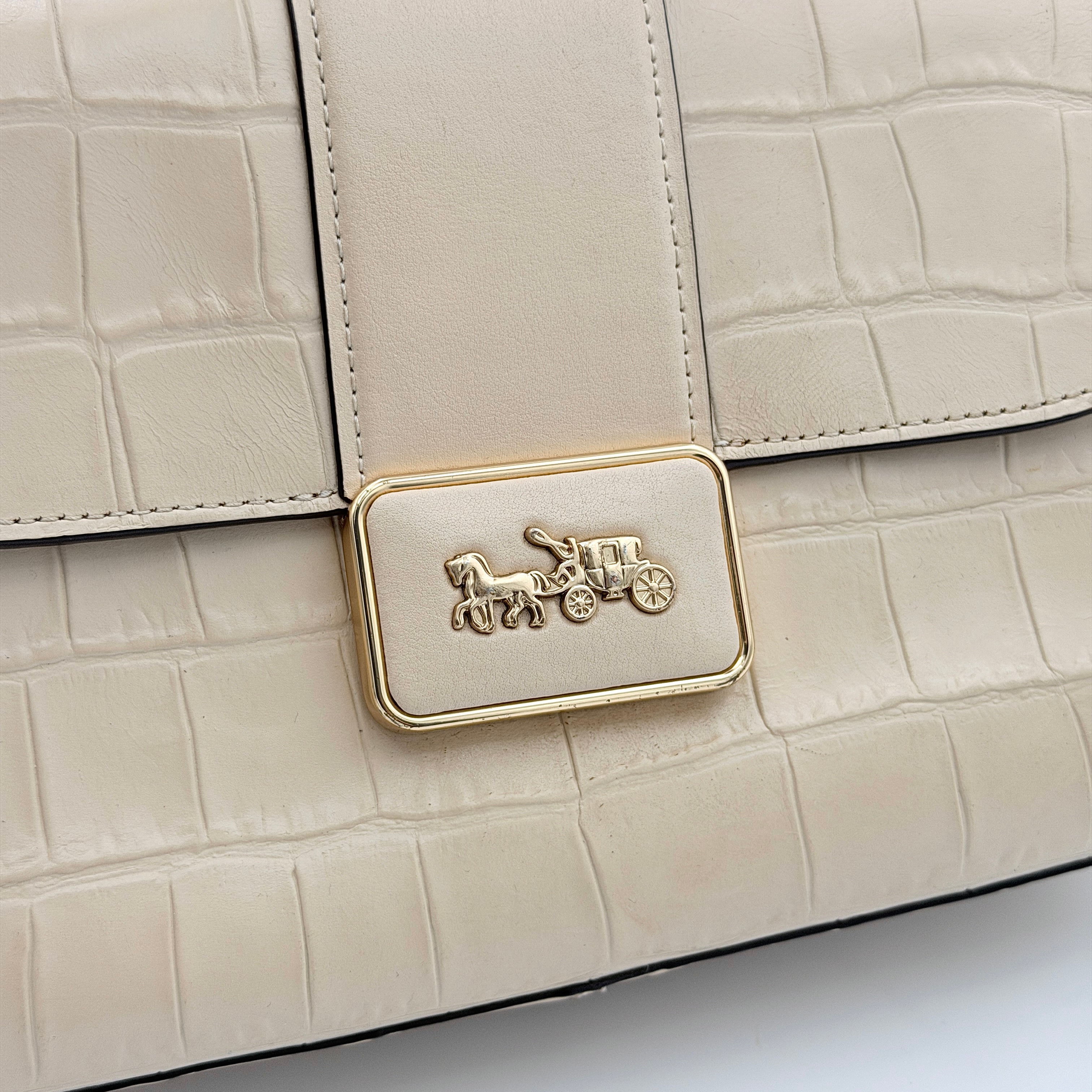 Coach Grace Shoulder Bag in ivory croc-embossed leather with gold-tone carriage plaque and structured shoulder strap.