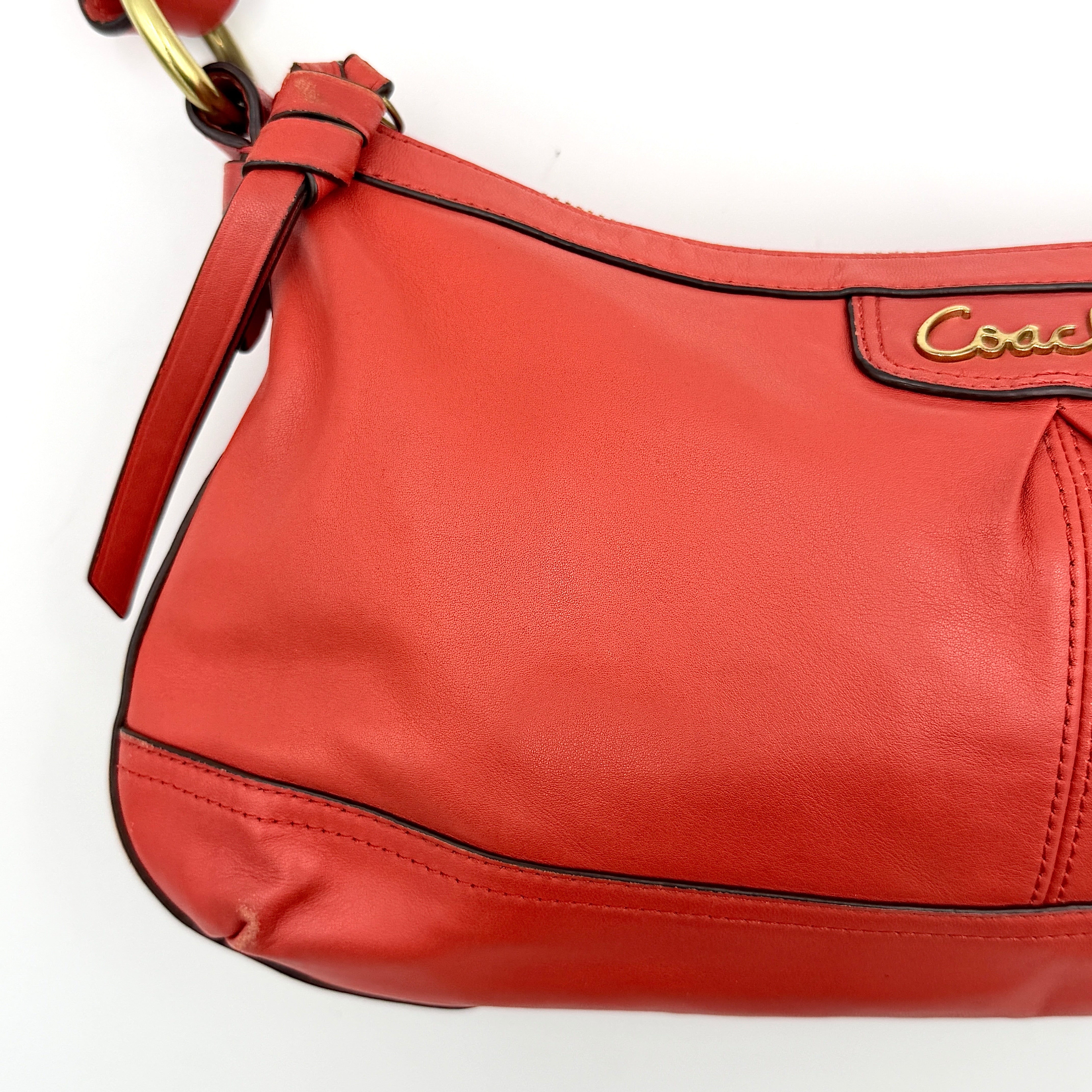 Coach 2Way Park Shoulder Bag in orange leather with gold hardware and adjustable strap, displayed against a white background.