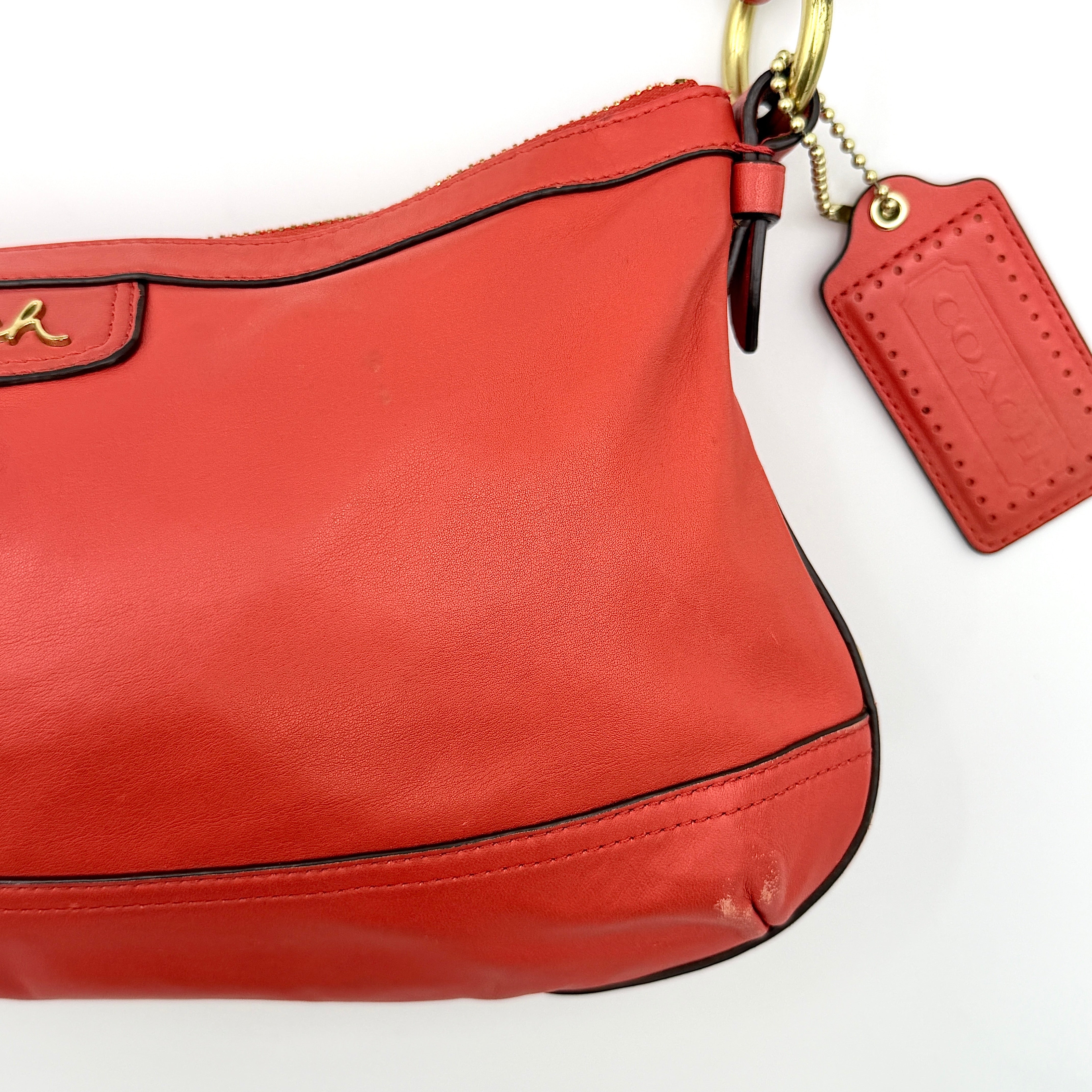 Coach 2Way Park Shoulder Bag in orange leather with gold hardware and adjustable strap, displayed against a white background.