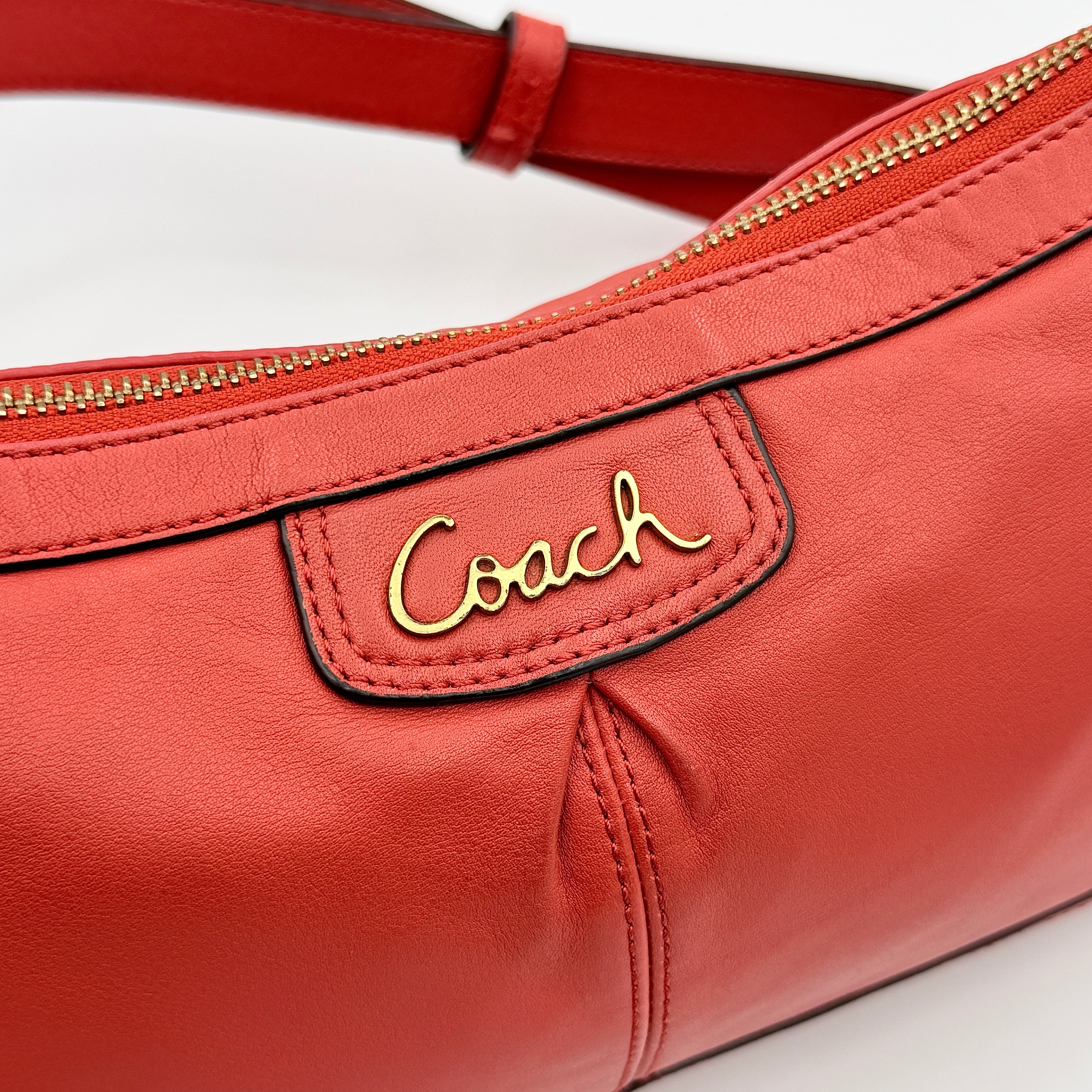 Coach 2Way Park Shoulder Bag in orange leather with gold hardware and adjustable strap, displayed against a white background.